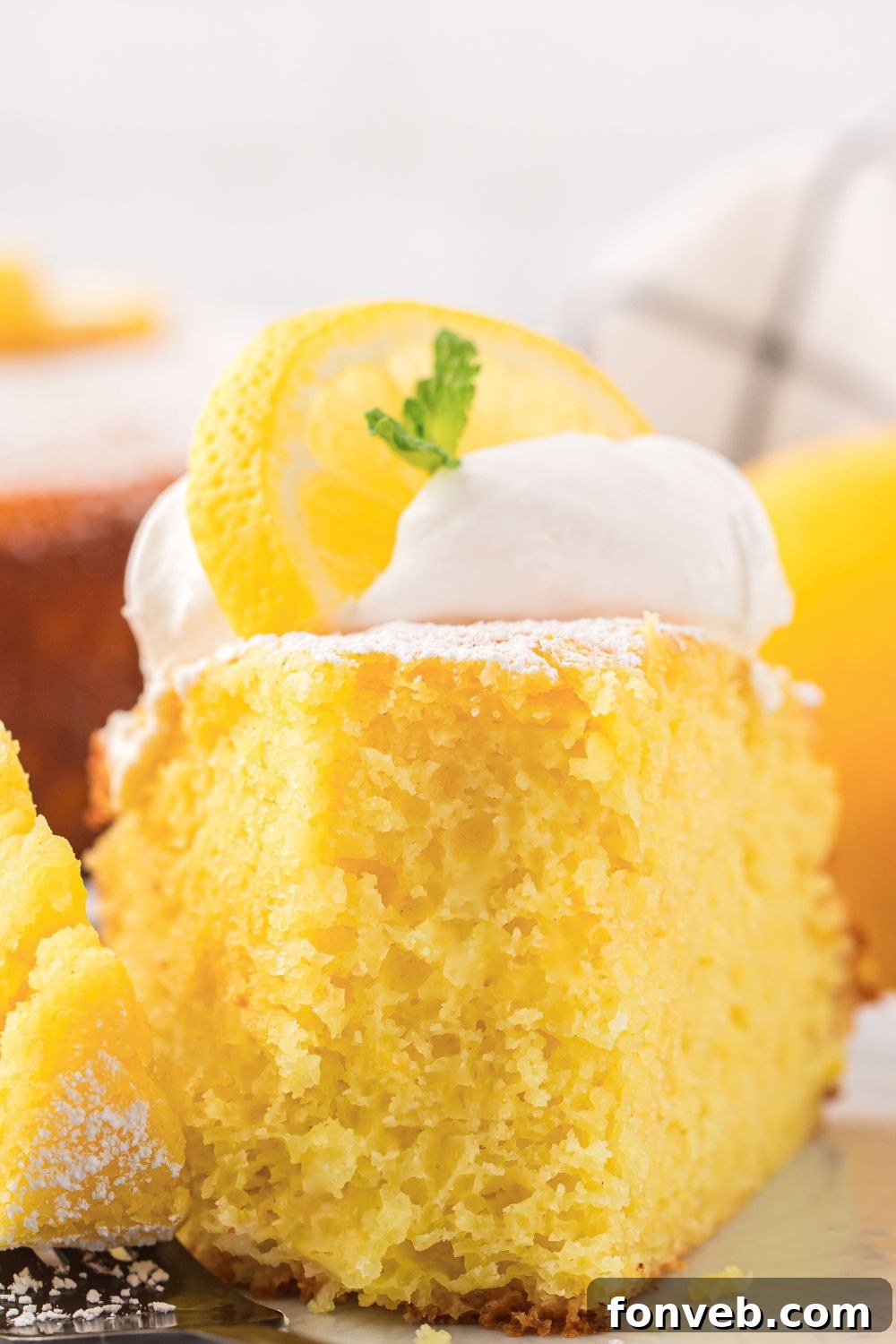 slice of Italian Lemon Ricotta Cake with a fork bite taken out of it on a plate on table 