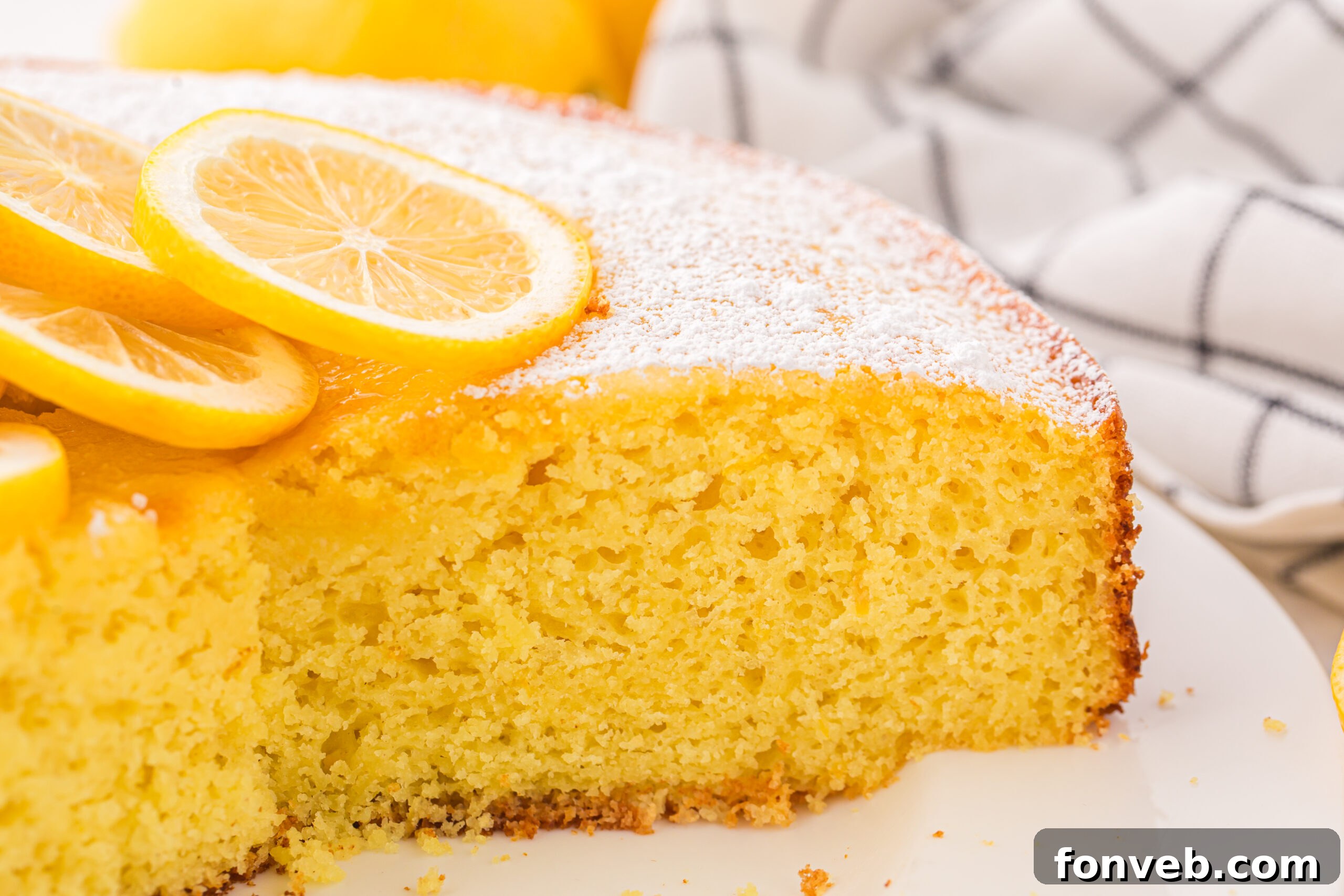 sliced Italian Lemon Ricotta Cake on a plate with a couple slices missing 