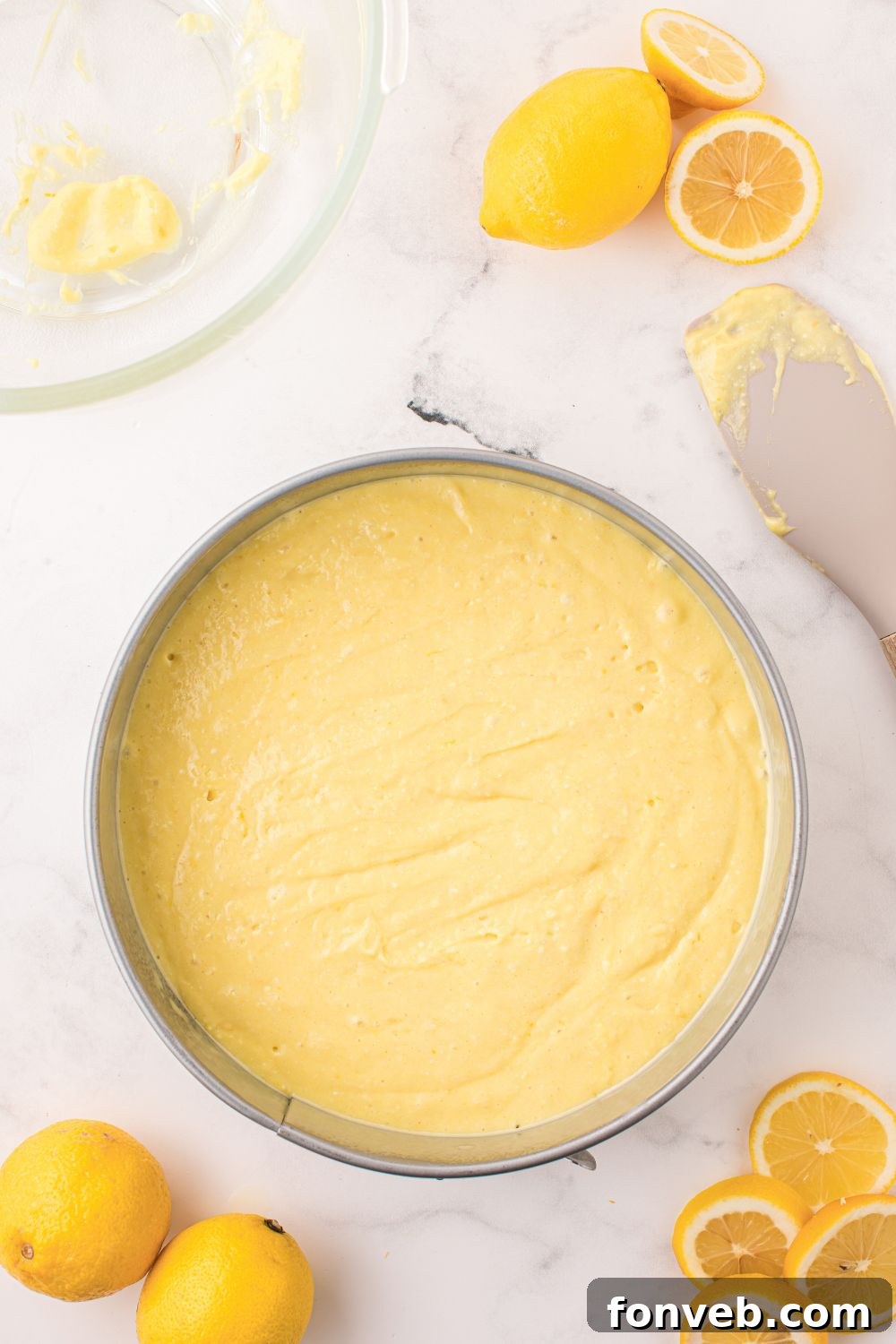 raw cake batter for Lemon Ricotta Cake in a round pan on table 