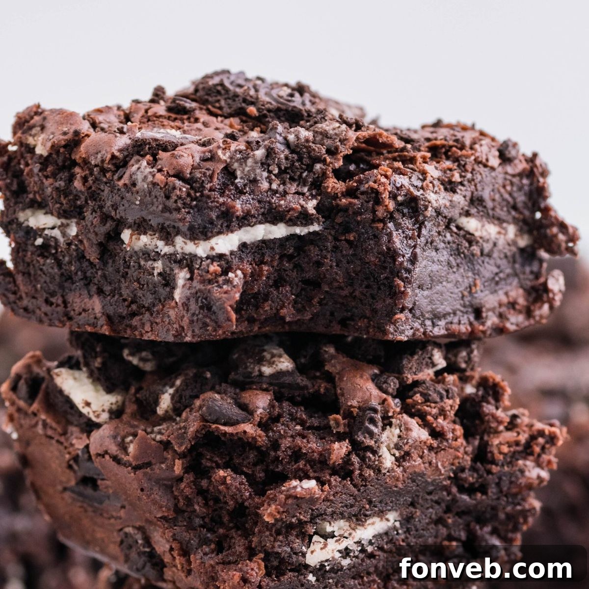 Decadent Oreo Stuffed Fudgy Brownies 3 Oreo Stuffed Brownies stacked on top of one another on table