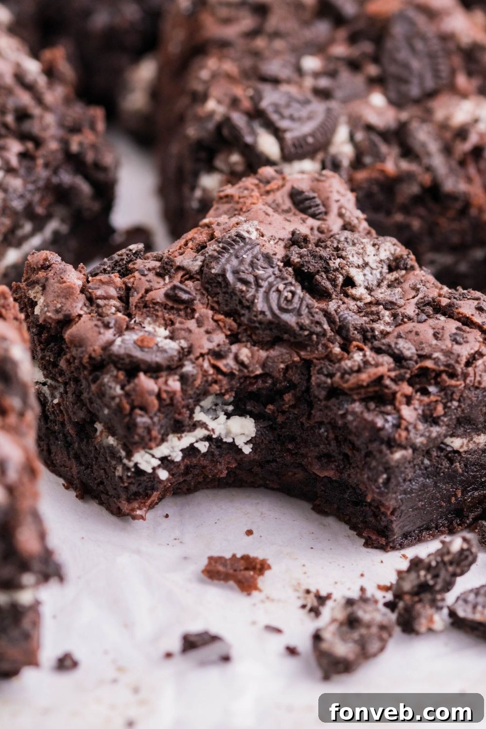 Decadent Oreo Stuffed Fudgy Brownies 4 Oreo Stuffed Brownies on table with a bite taken out of one of the brownies