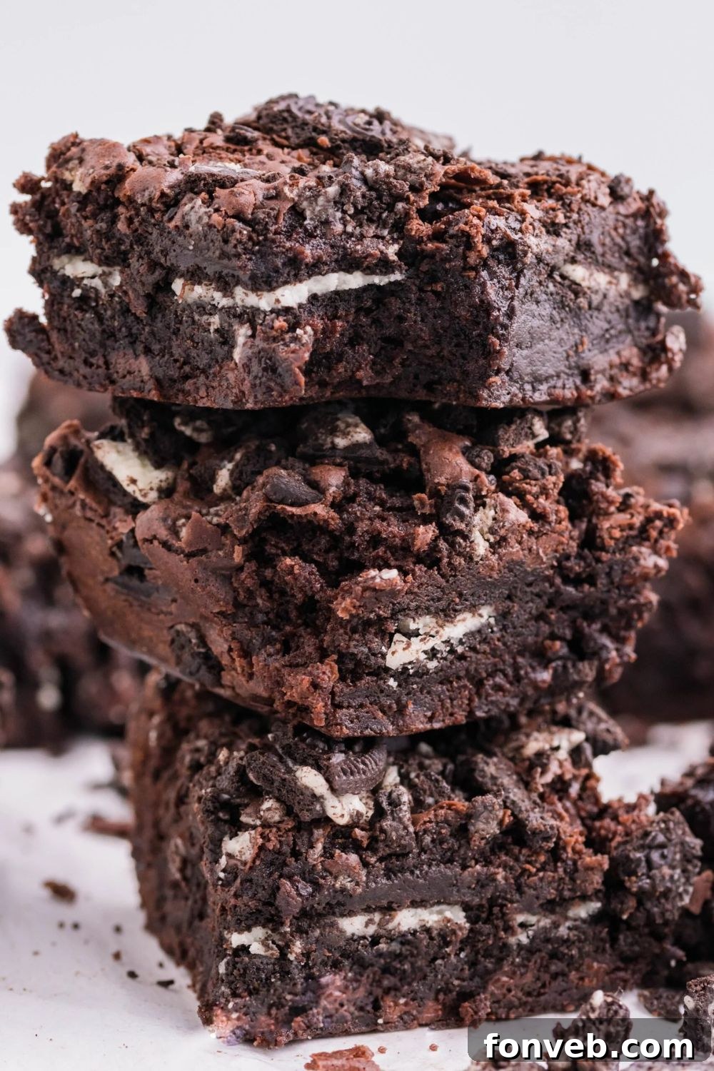 Decadent Oreo Stuffed Fudgy Brownies 5 Oreo Stuffed Brownies stacked on table to show the thick brownie layers