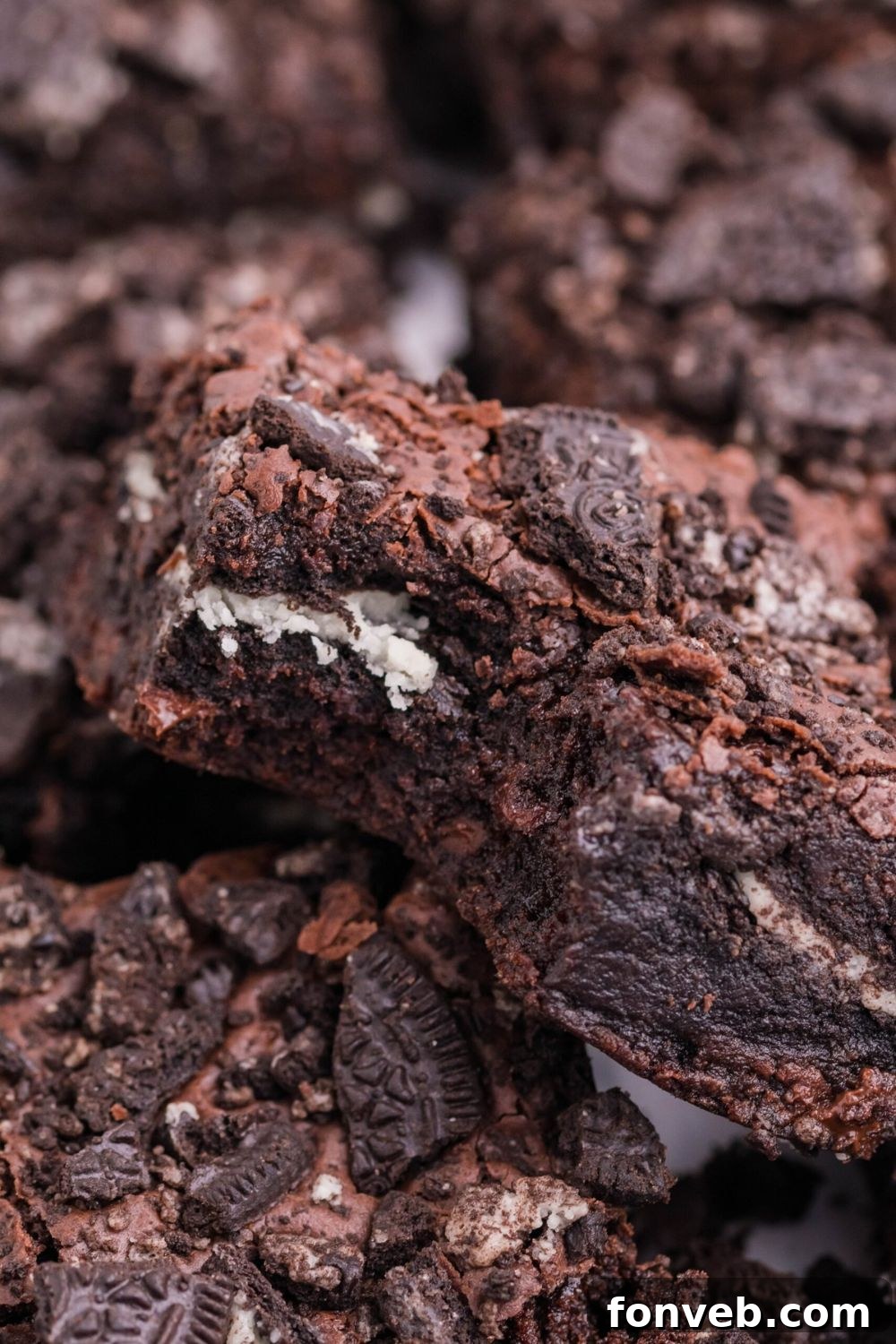 Decadent Oreo Stuffed Fudgy Brownies 9 Oreo Stuffed Brownies stacked on table with one that has a bit taken out of it