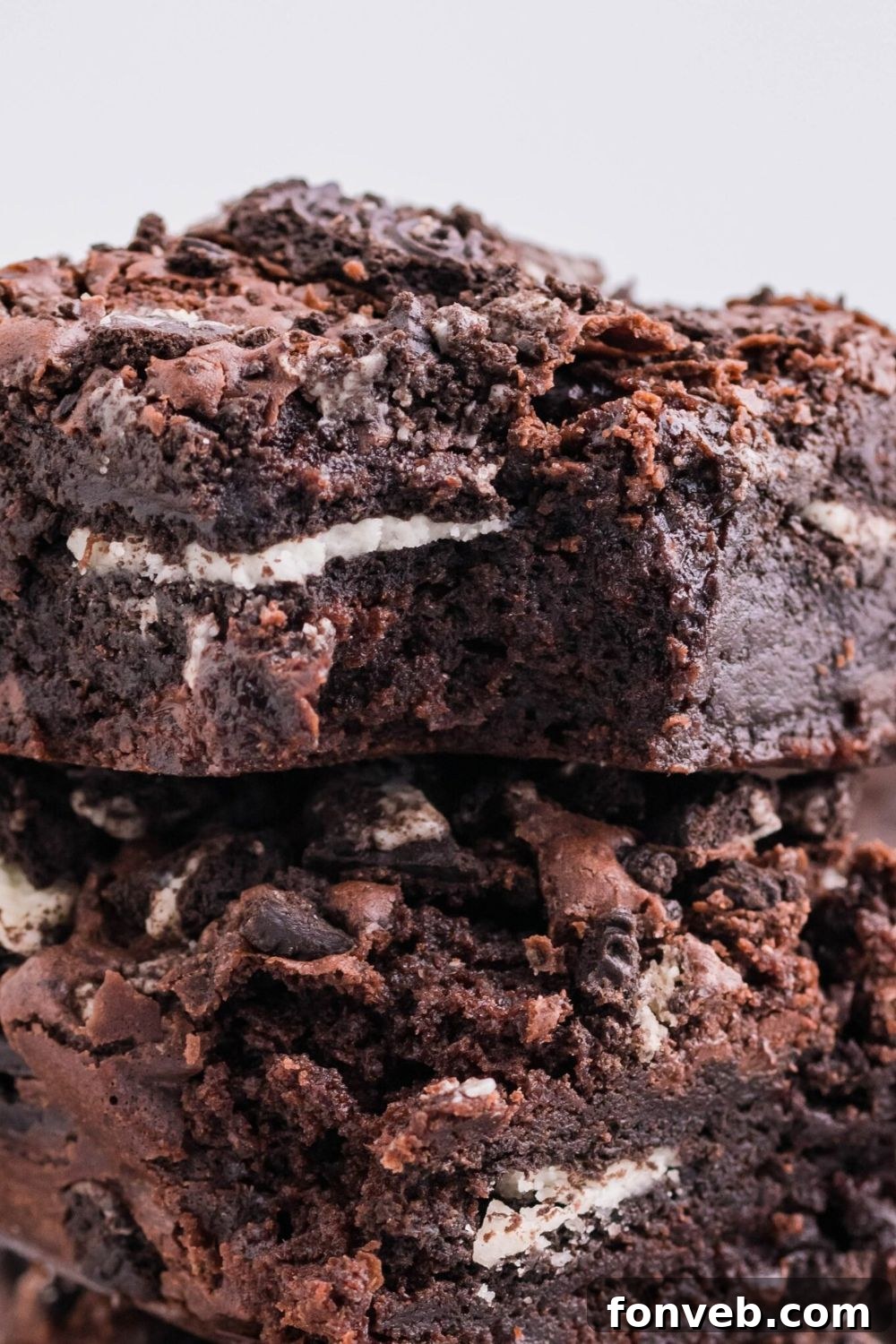 Decadent Oreo Stuffed Fudgy Brownies 10 stack of Oreo Stuffed Brownies on table showing the cookies on top of each brownie