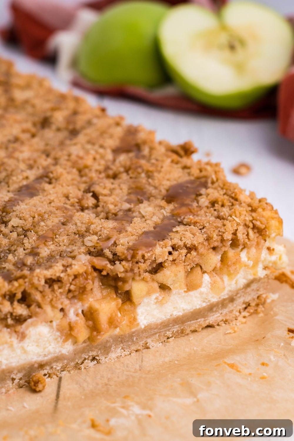 Caramel Apple Cheesecake Bars on table with a few cut off 