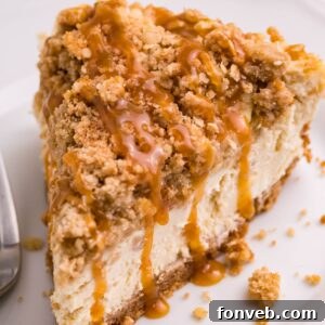 Caramel Apple Crisp Cheesecake sliced and placed on a plate with a fork to the side