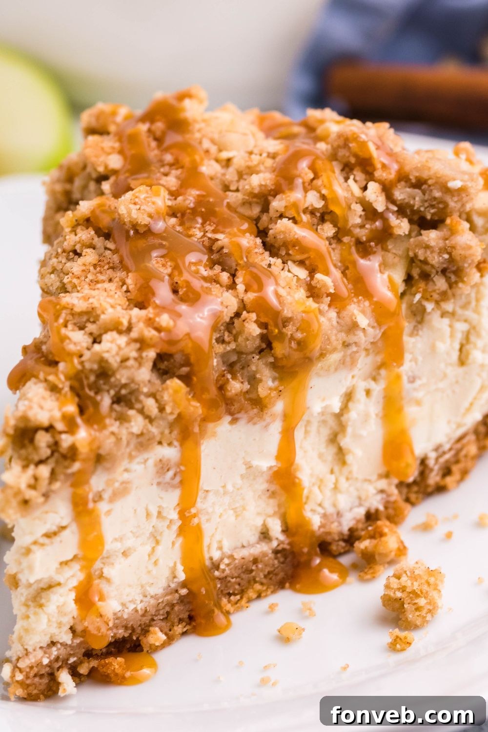 Decadent Caramel Apple Crumble Cheesecake 5 A close-up view of a slice of Caramel Apple Crisp Cheesecake on a plate, with luxurious caramel sauce artfully dripping down its sides, highlighting the rich, gooey texture.