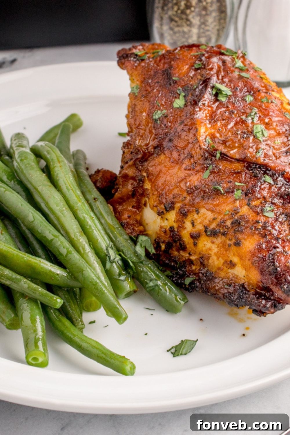Air Fryer Chicken Breast on plate with green beans to side of plate 