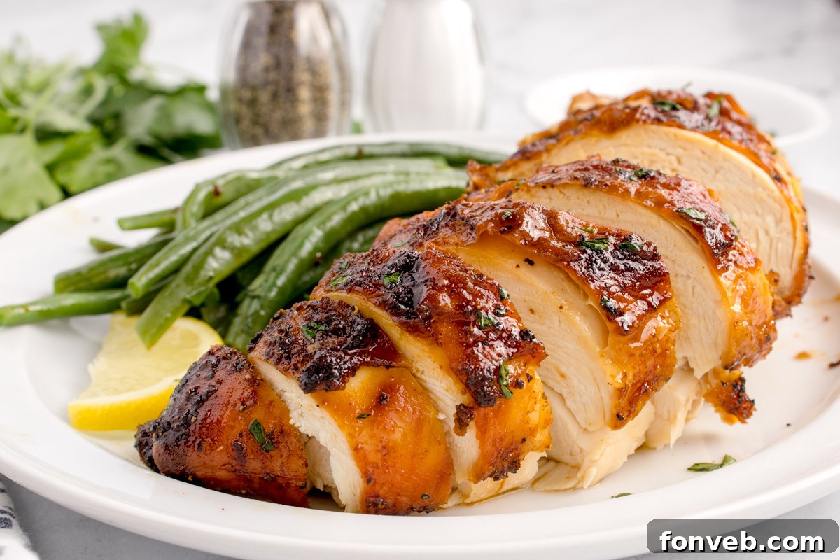 side view of the Air Fryer Chicken Breast sliced on table with some vegetables to side of the chicken