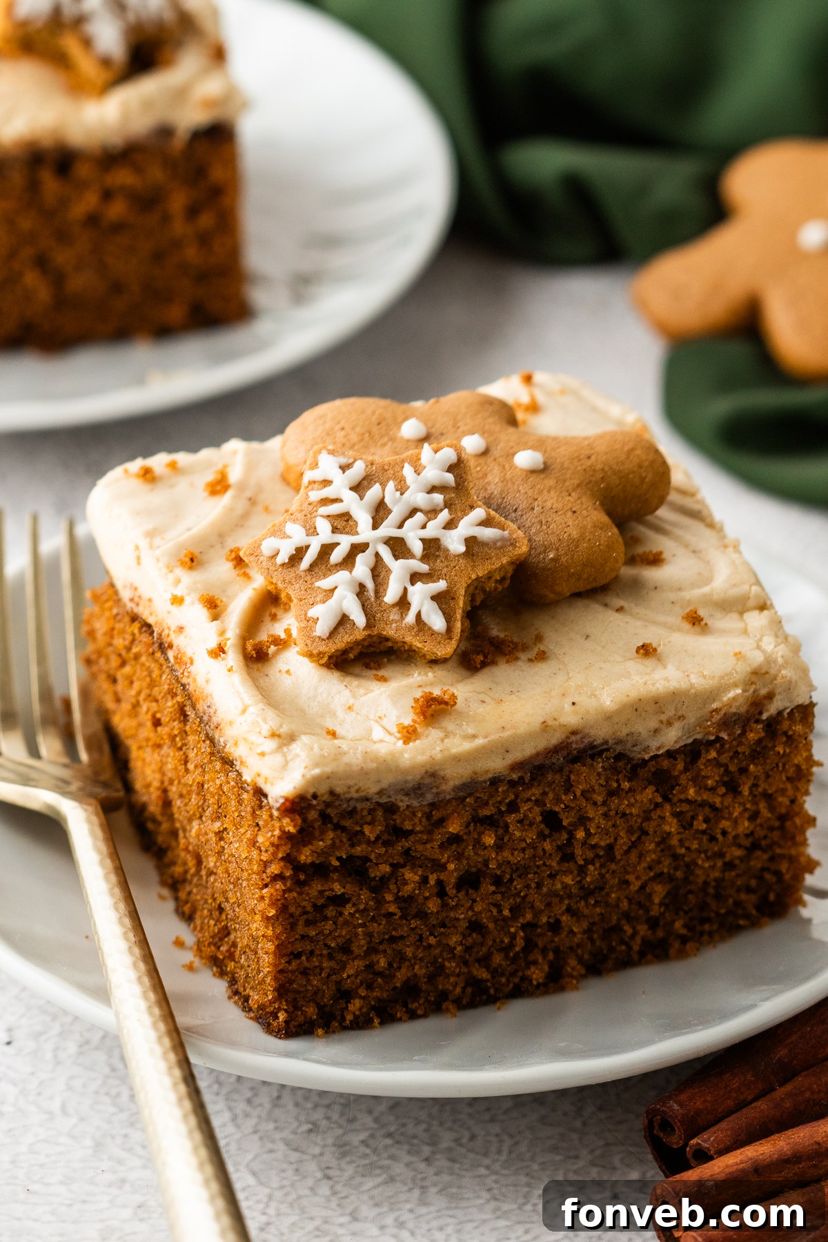 slice of Gingerbread Cake with Cream Cheese Frosting on plates sitting on table with main cake in pan