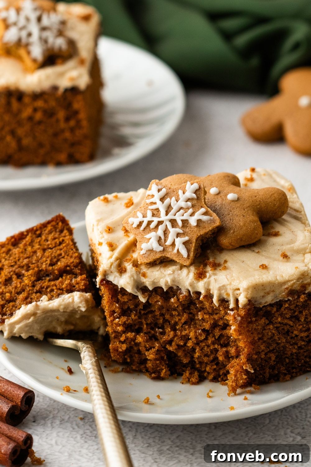 slice of Gingerbread Cake with Cream Cheese Frosting with a bite taken off sitting on fork on table