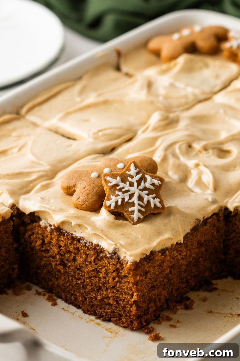 close up of pan with Gingerbread Cake with Cream Cheese Frosting in it with a handful of pieces missing in pan