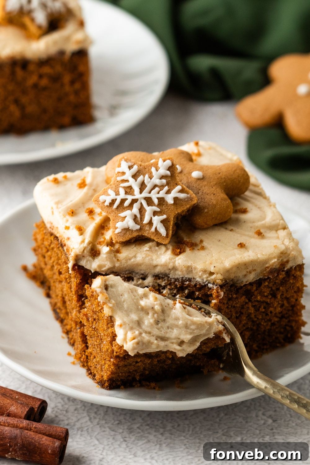 slice of Gingerbread Cake with Cream Cheese Frosting on pan with a fork poking into cake for taking a bite out of it