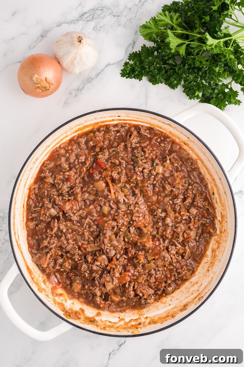 Close-up of the rich ground beef sauce simmering in a skillet, showcasing its thick and savory texture