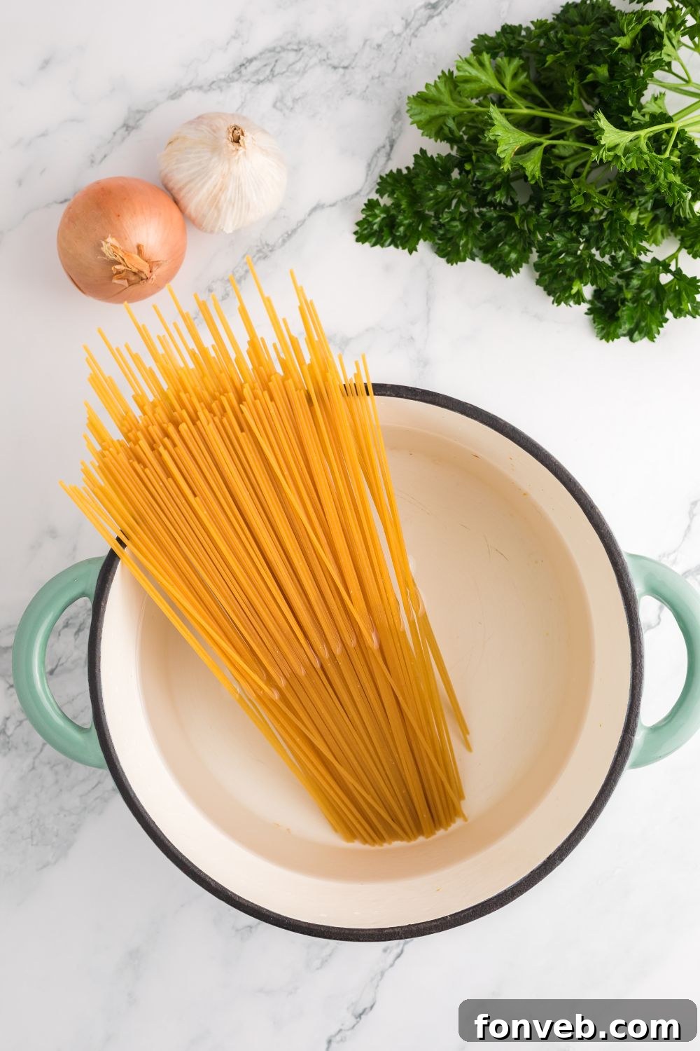 Dry spaghetti cooking in a large pot of boiling water on a stovetop
