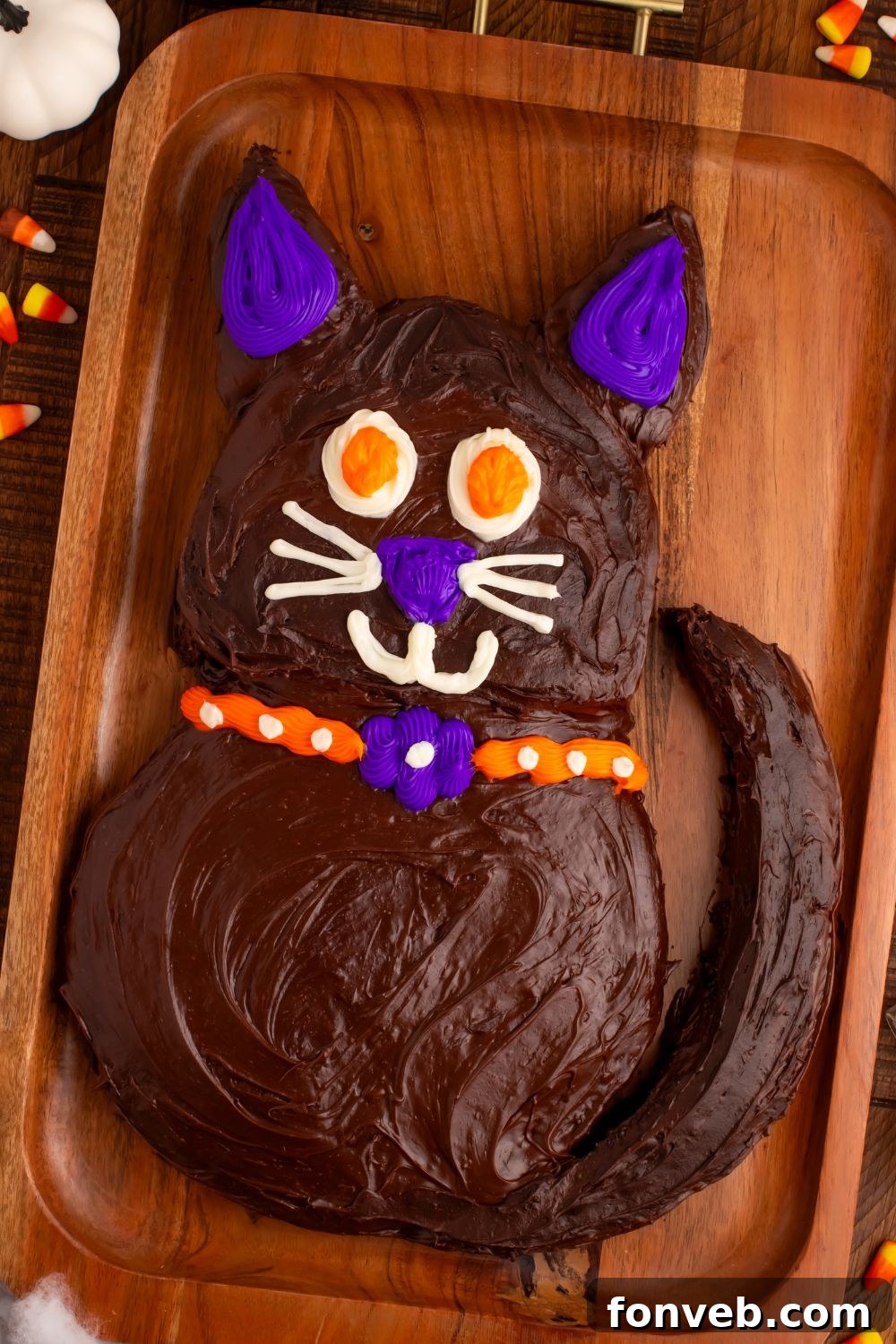 Purrfectly Simple 4-Ingredient Black Cat Halloween Cake 11 Side view of Easy Halloween Black Cat Cut Out Cake on a serving tray with candy corn around it, highlighting the cake's profile