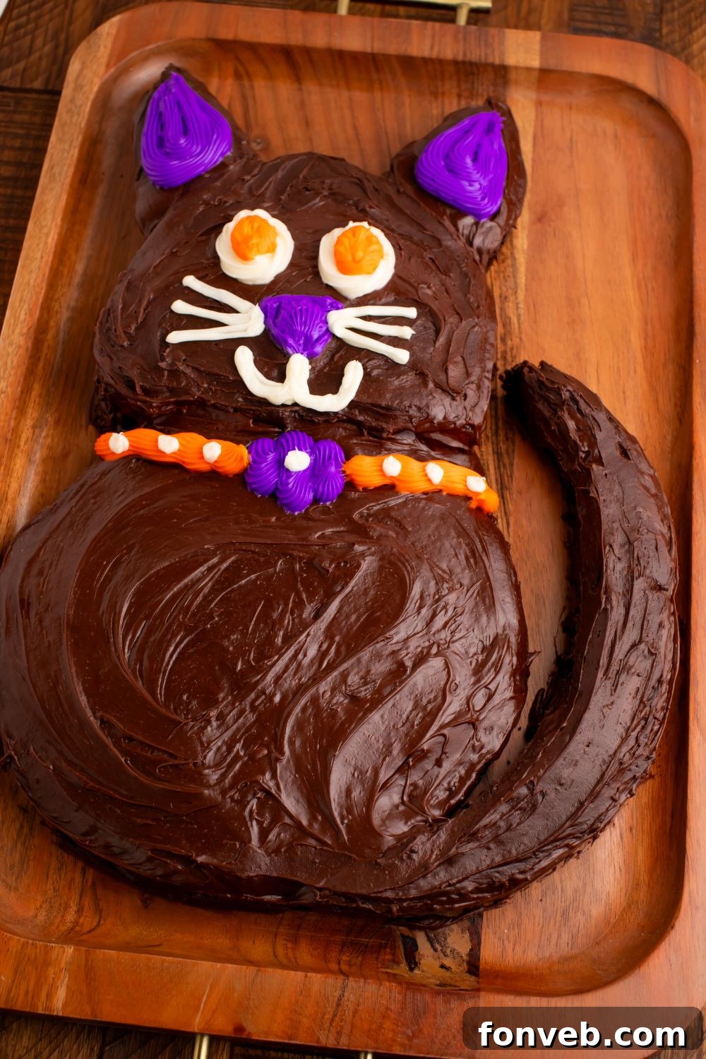 Purrfectly Simple 4-Ingredient Black Cat Halloween Cake 17 Side view of Easy Halloween Black Cat Cut Out Cake on a tray so you can see the whole cat on the table, a delightful Halloween dessert