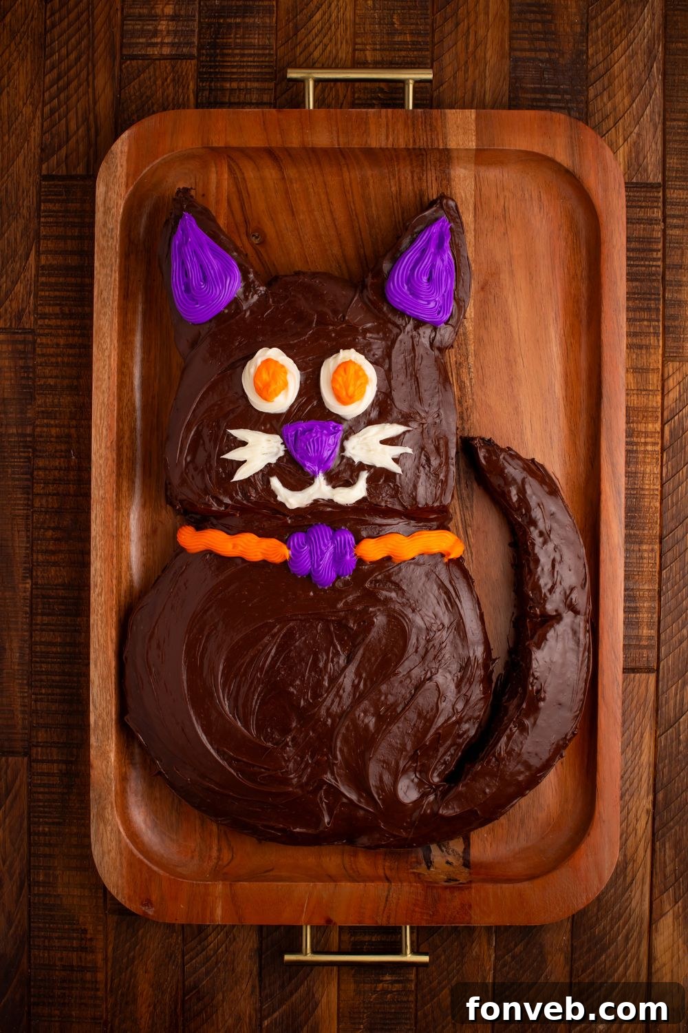 Purrfectly Simple 4-Ingredient Black Cat Halloween Cake 9 Fully decorated Easy Halloween Black Cat Cut Out Cake on tray on table, complete with candy eyes and whiskers