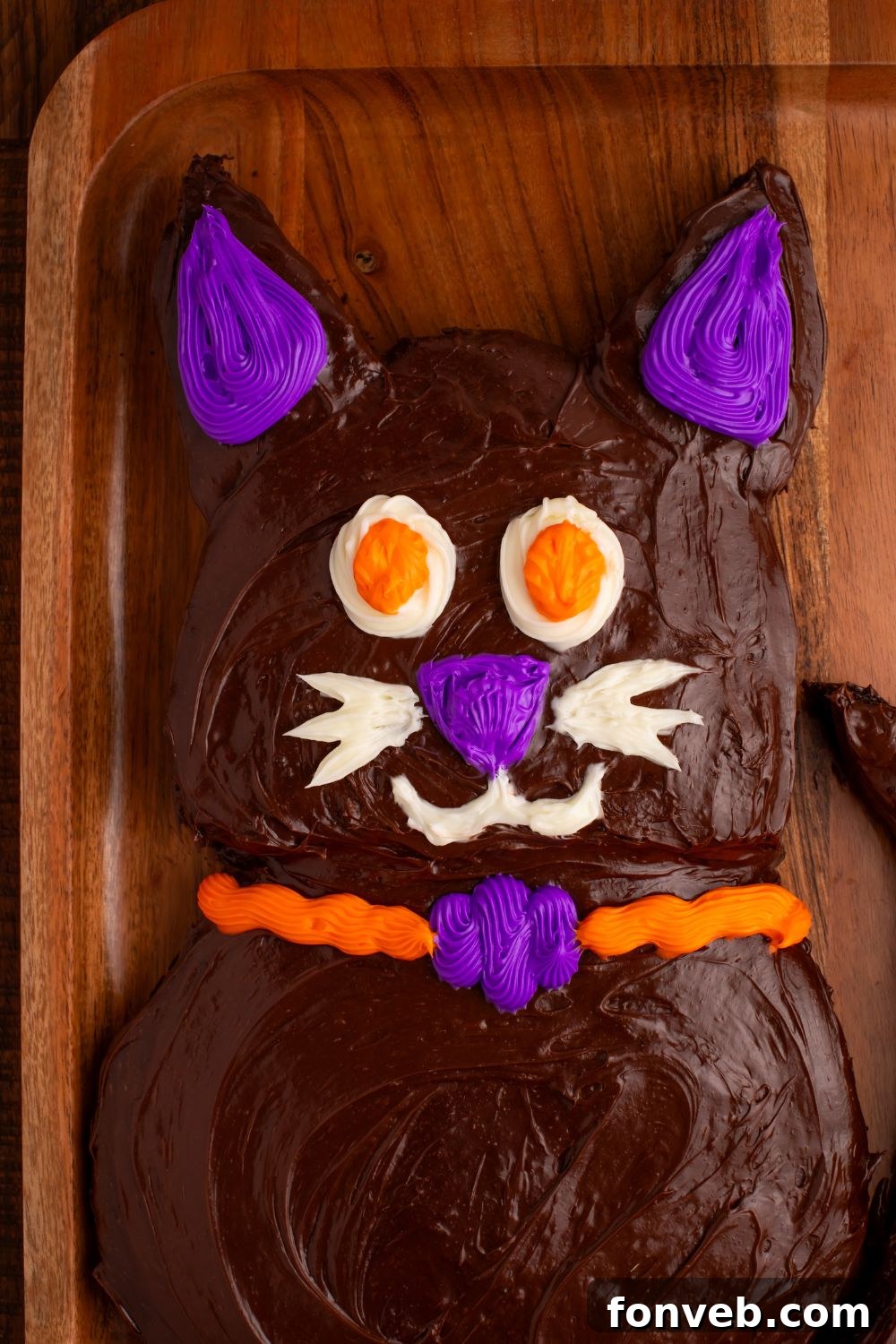 Purrfectly Simple 4-Ingredient Black Cat Halloween Cake 10 Close up of Halloween cat cake on a wooden tray, showing intricate frosting details and candy eyes