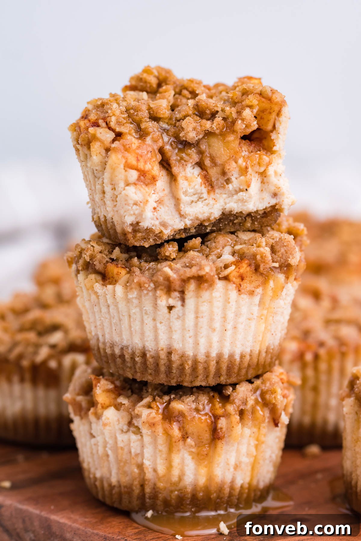 Stack of 3 Apple Crisp Cheesecakes with a bite missing from the top one