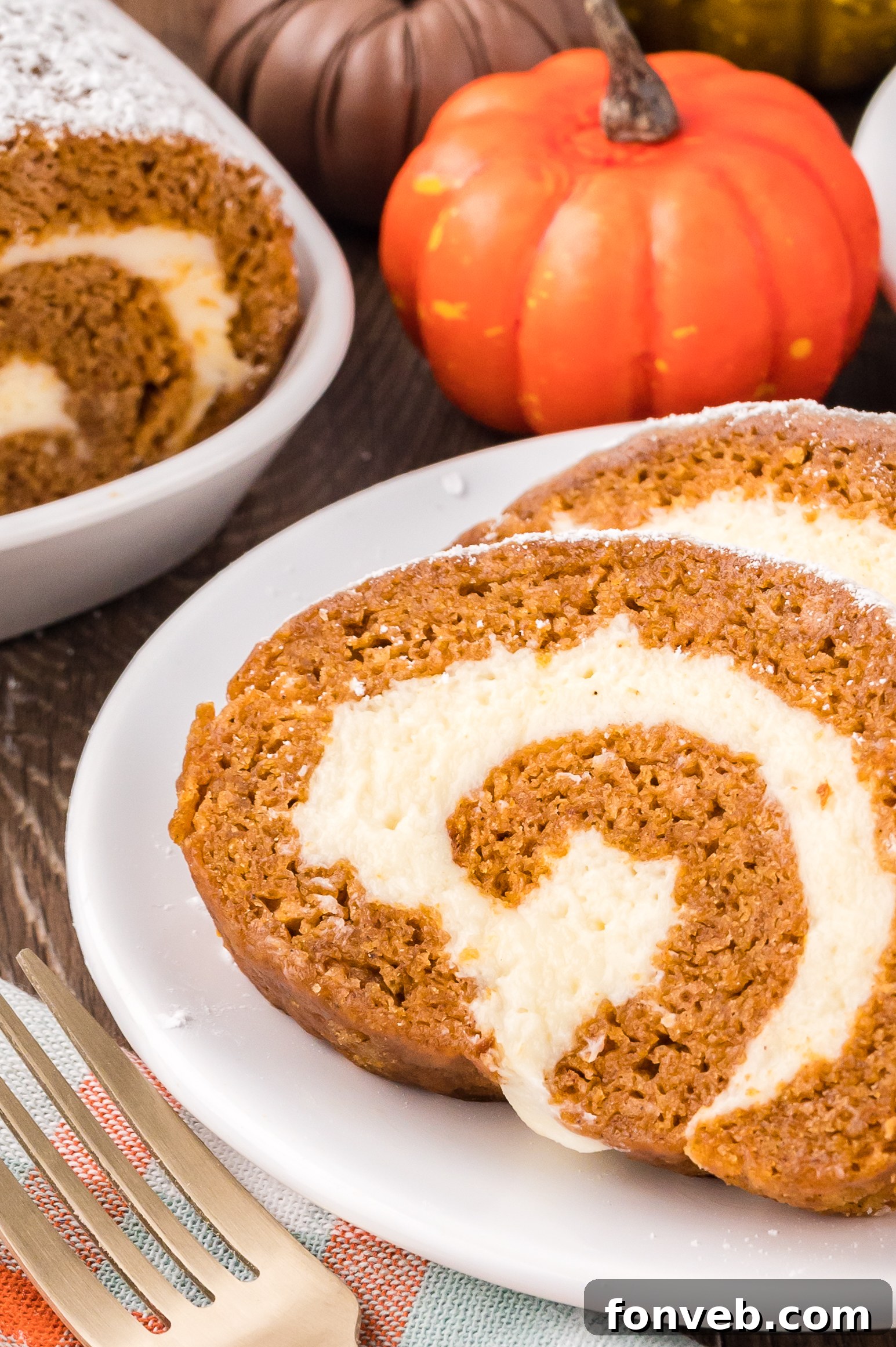 Classic Spiced Pumpkin Roll 2 Slices of the Pumpkin Cake Roll on a white plate