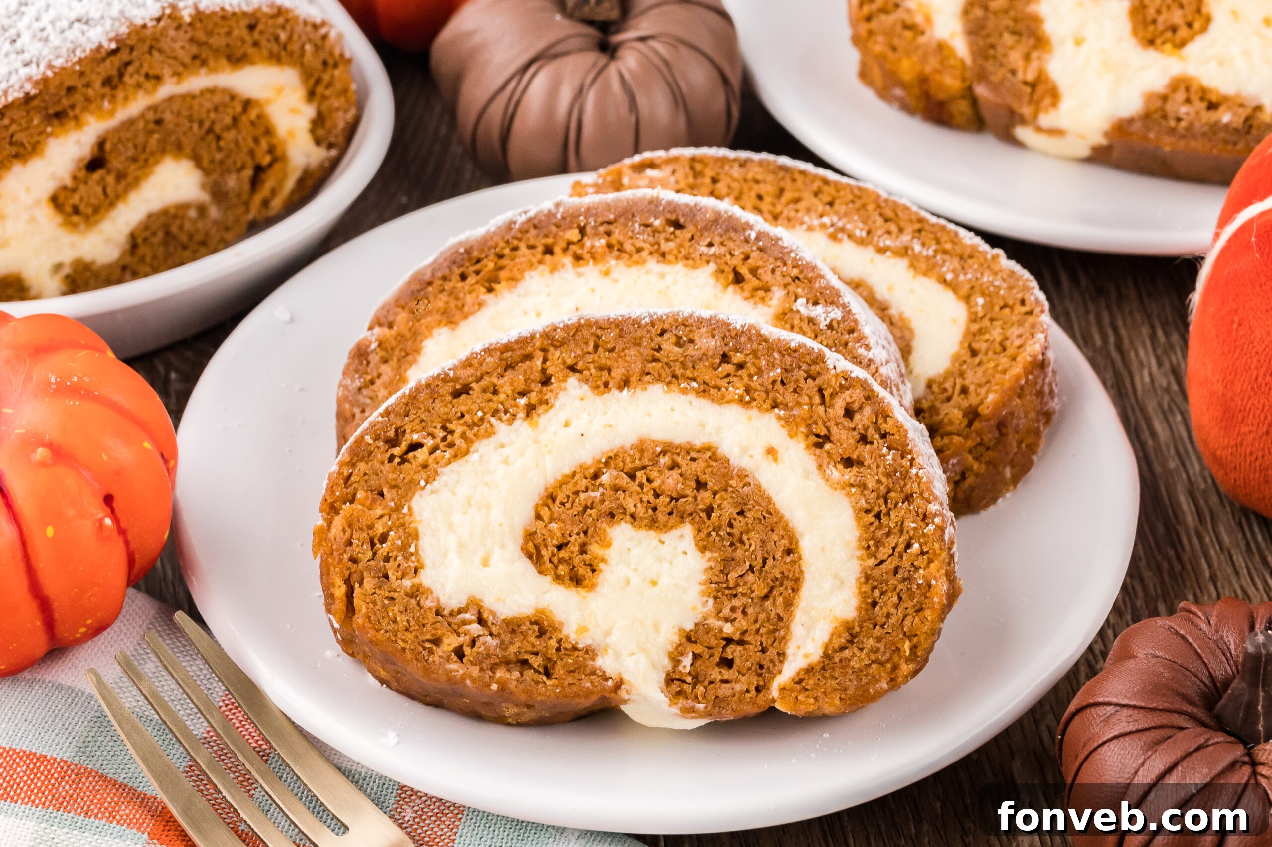 Classic Spiced Pumpkin Roll 26 Pumpkin Cake Roll slice on a white plate on top of a dark wood table