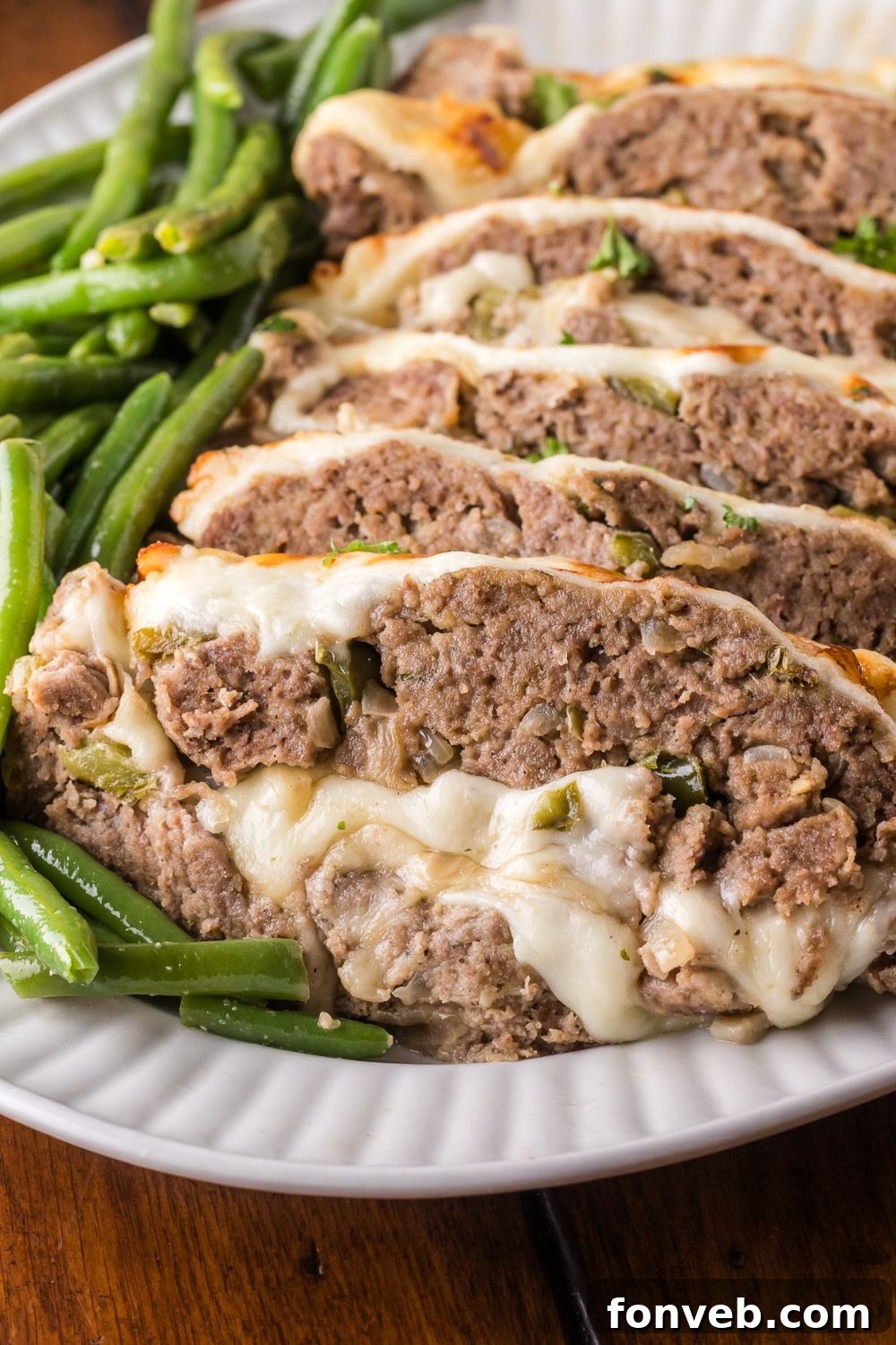 platter with greens on it, and then topped with sliced Stuffed Philly Cheesesteak Meatloaf  