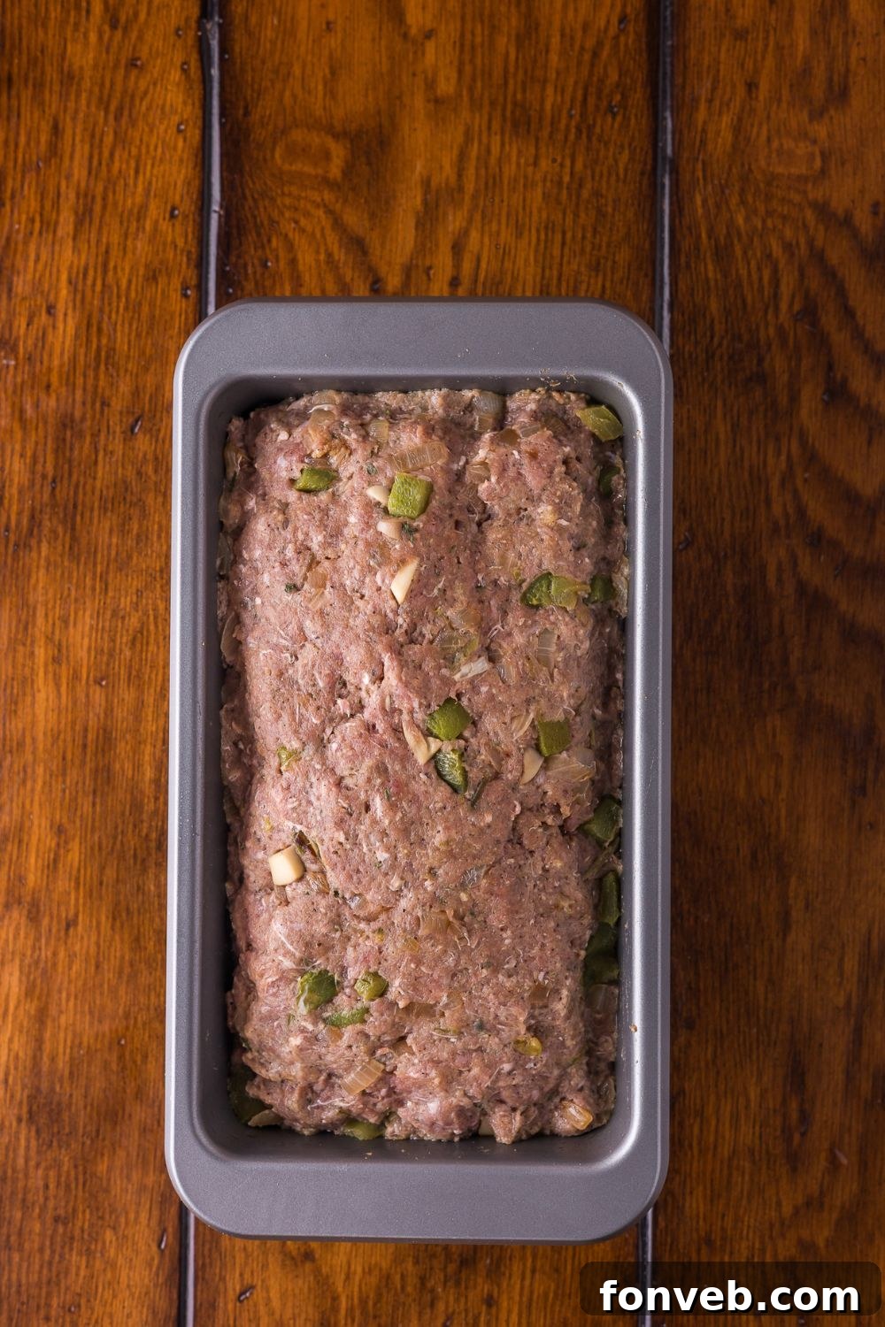 raw Stuffed Philly Cheesesteak Meatloaf in a loaf pan sitting on table 