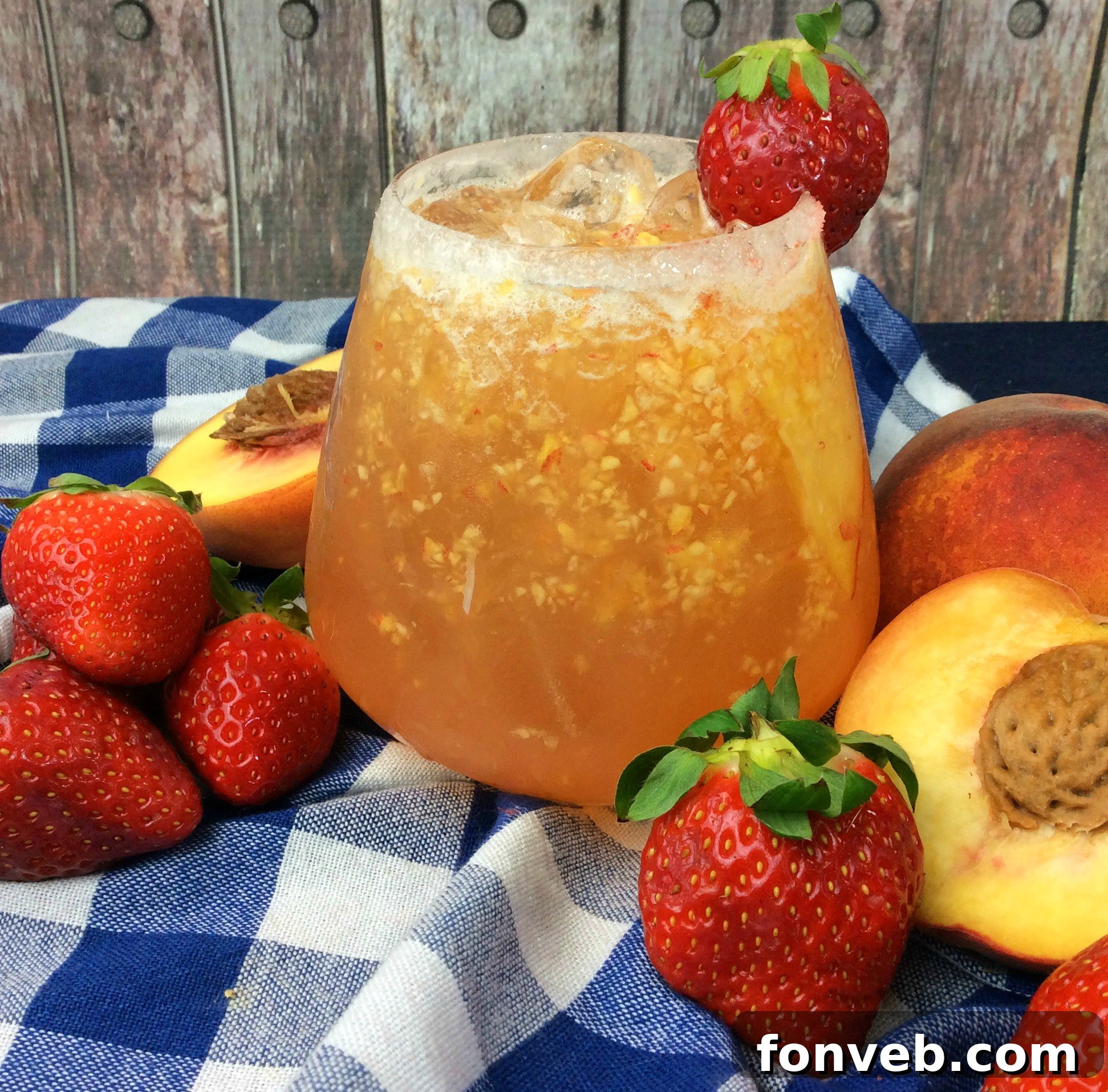 The Georgia Peach Flirt 3 Two glasses of peach cocktail, elegantly presented on a rustic wooden surface.