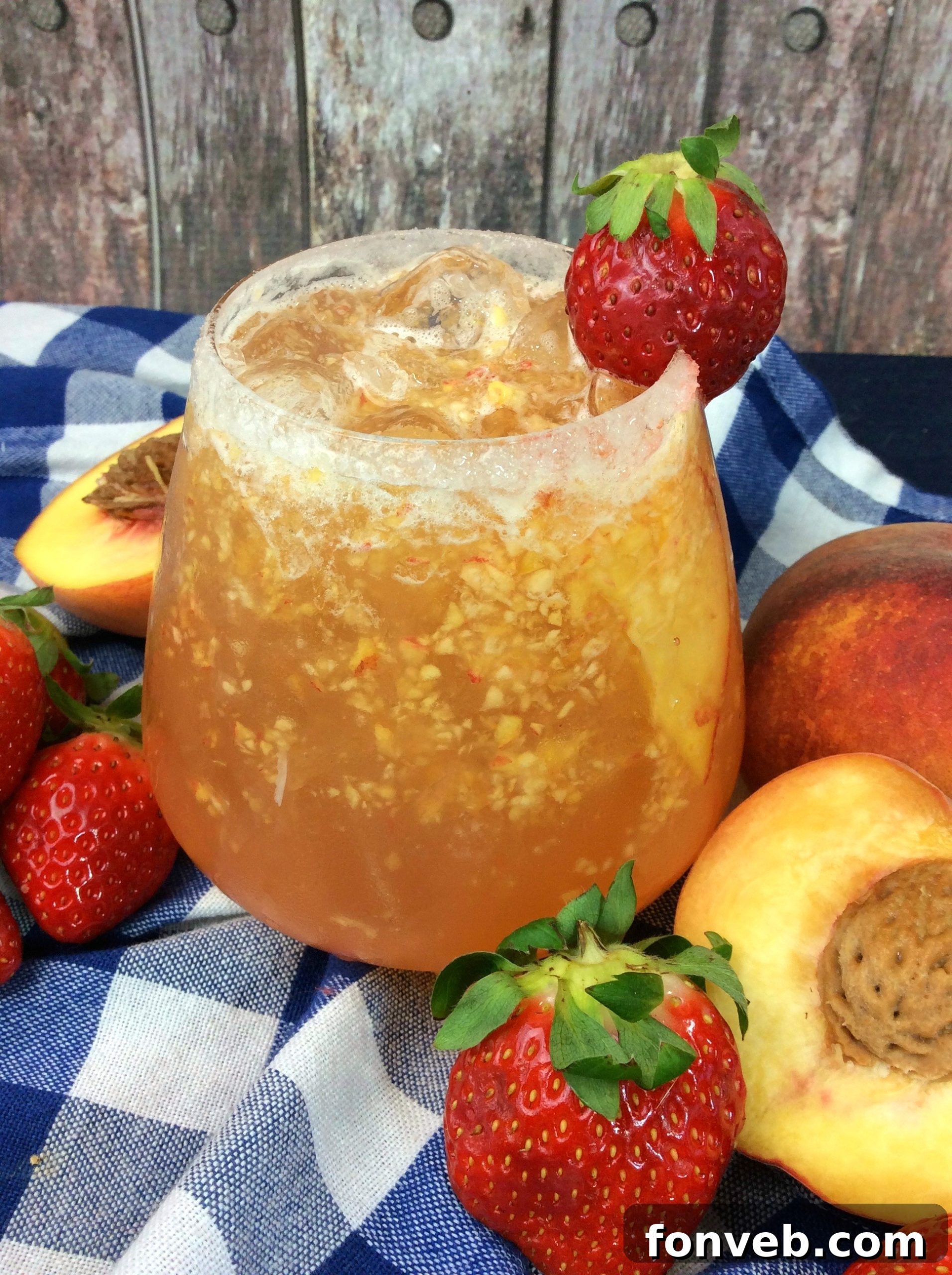 The Georgia Peach Flirt 4 Close-up of a peach cocktail with ice and a peach slice garnish.