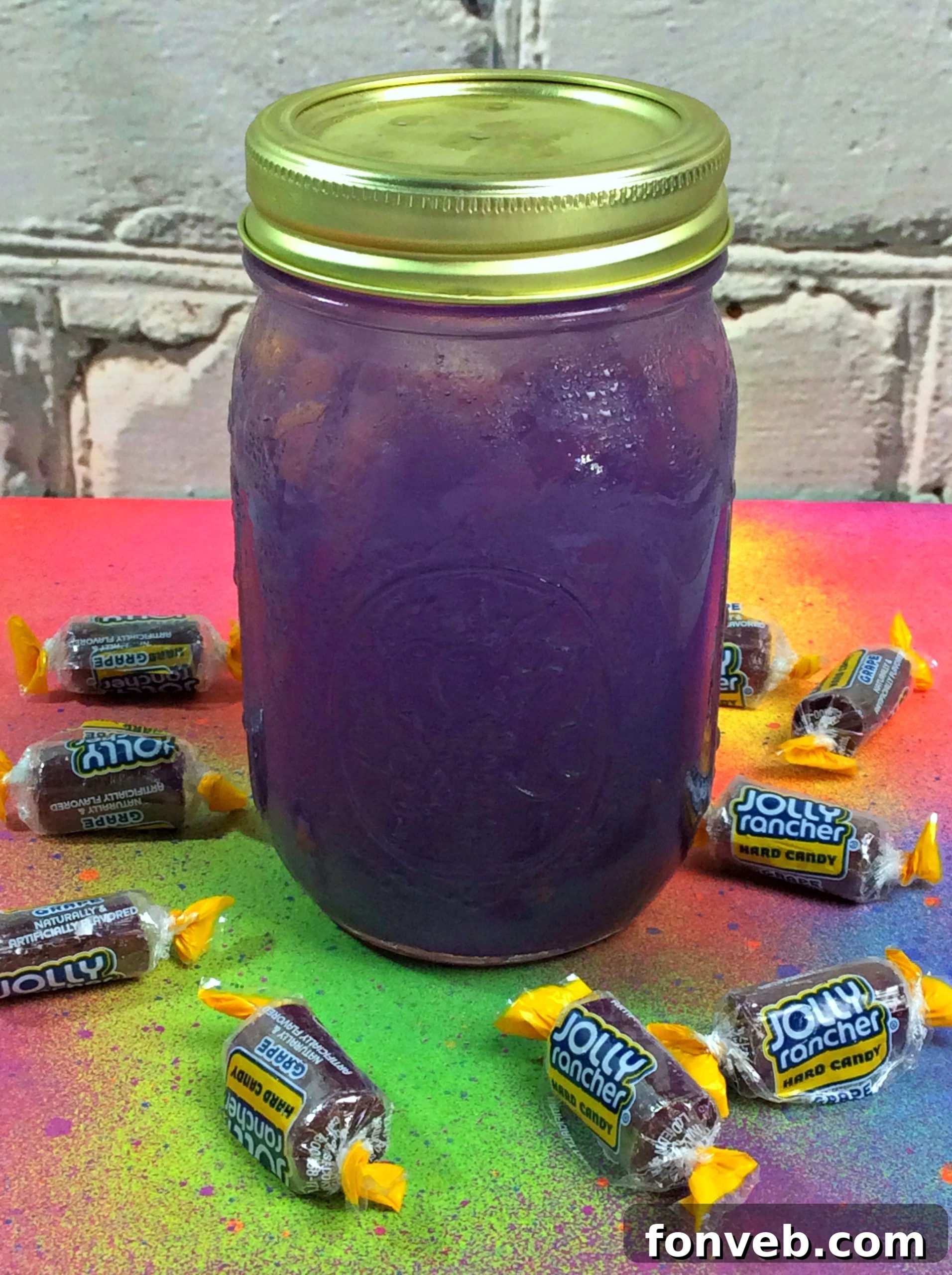 Close-up of Grape Jolly Rancher Moonshine in a glass with a purple candy backdrop