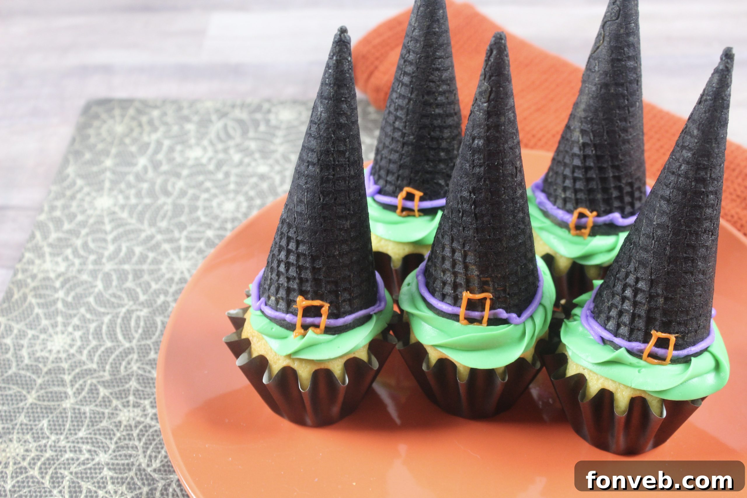Wicked Witch Hat Cupcakes 11 A decorated witch hat, showcasing the piped purple band and orange buckle, ready to be placed on a cupcake.