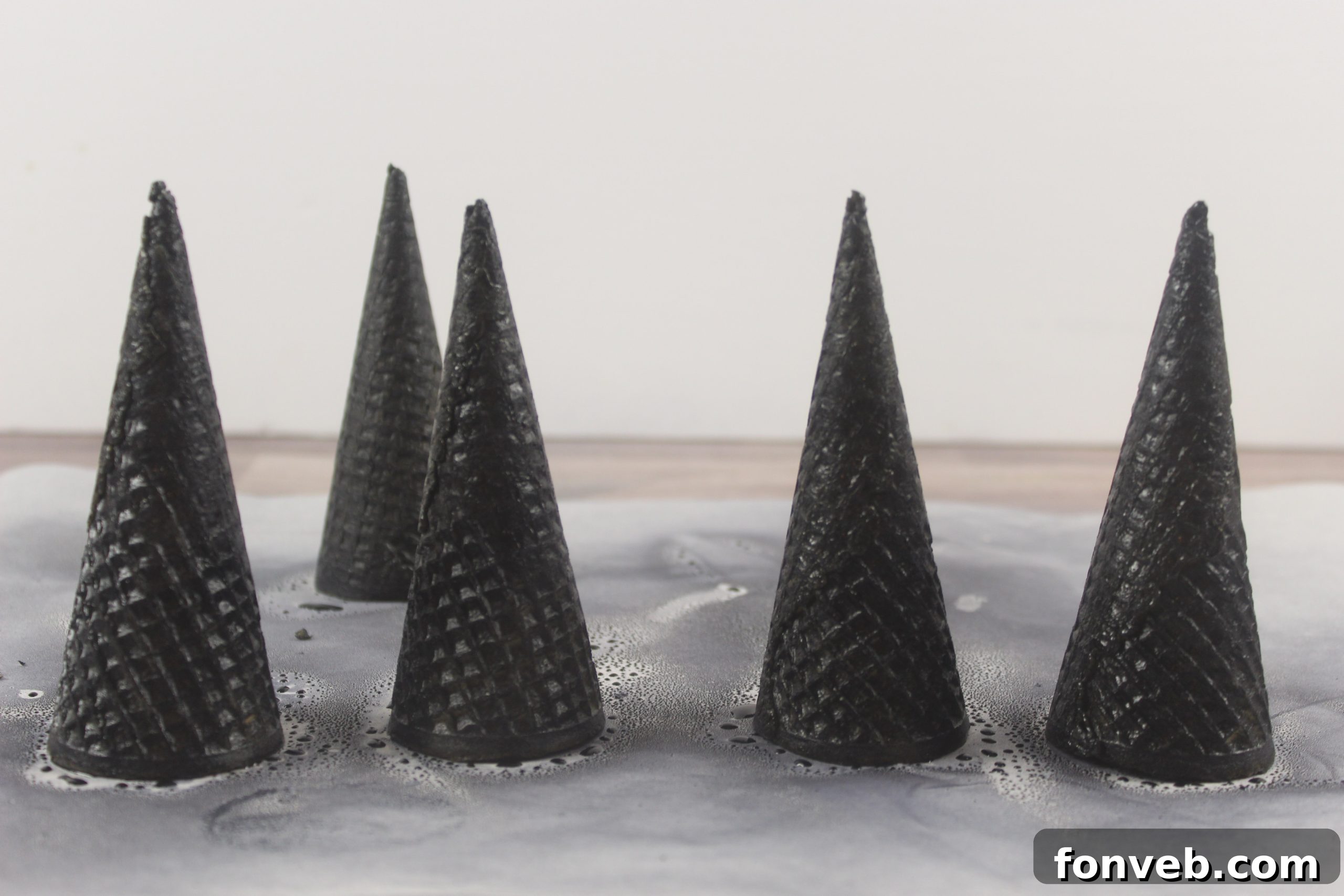 Wicked Witch Hat Cupcakes 8 Demonstration of spraying a sugar cone with edible black color mist.