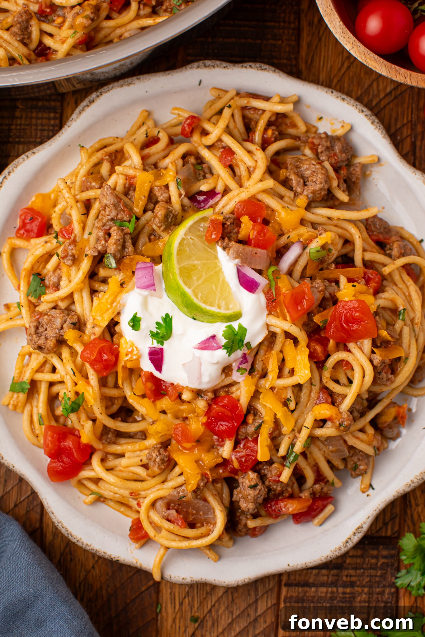 One Pot Cheesy Taco Spaghetti 21 Plate of Cheesy Taco Spaghetti topped with sour cream and lime