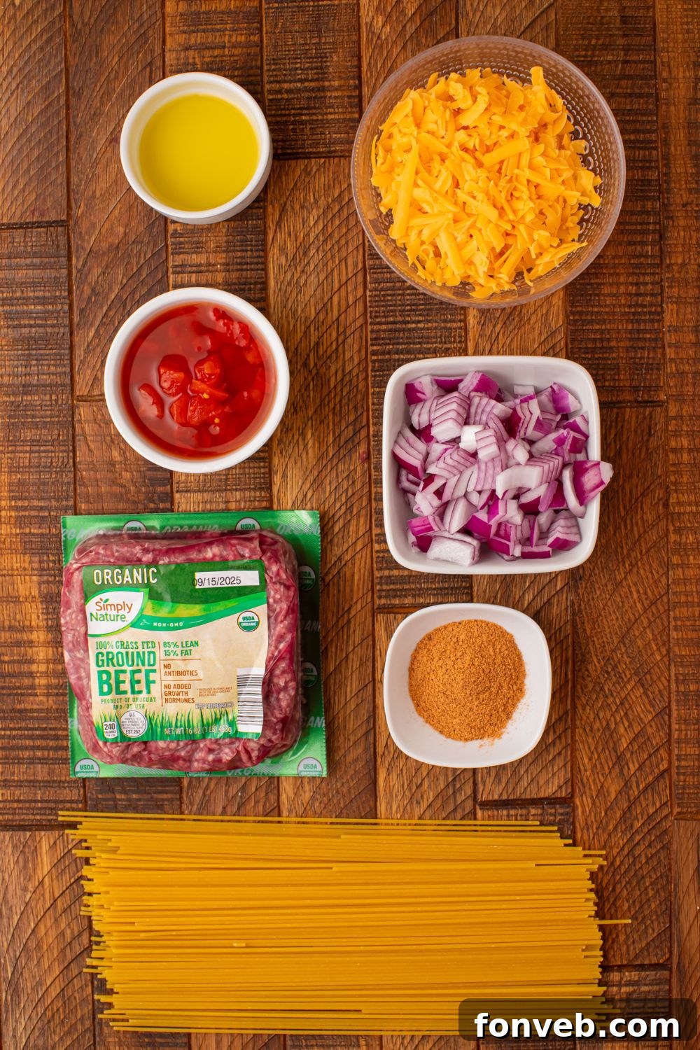 One Pot Cheesy Taco Spaghetti 5 a wooden table full of items to make taco spaghetti in single serve small bowls.