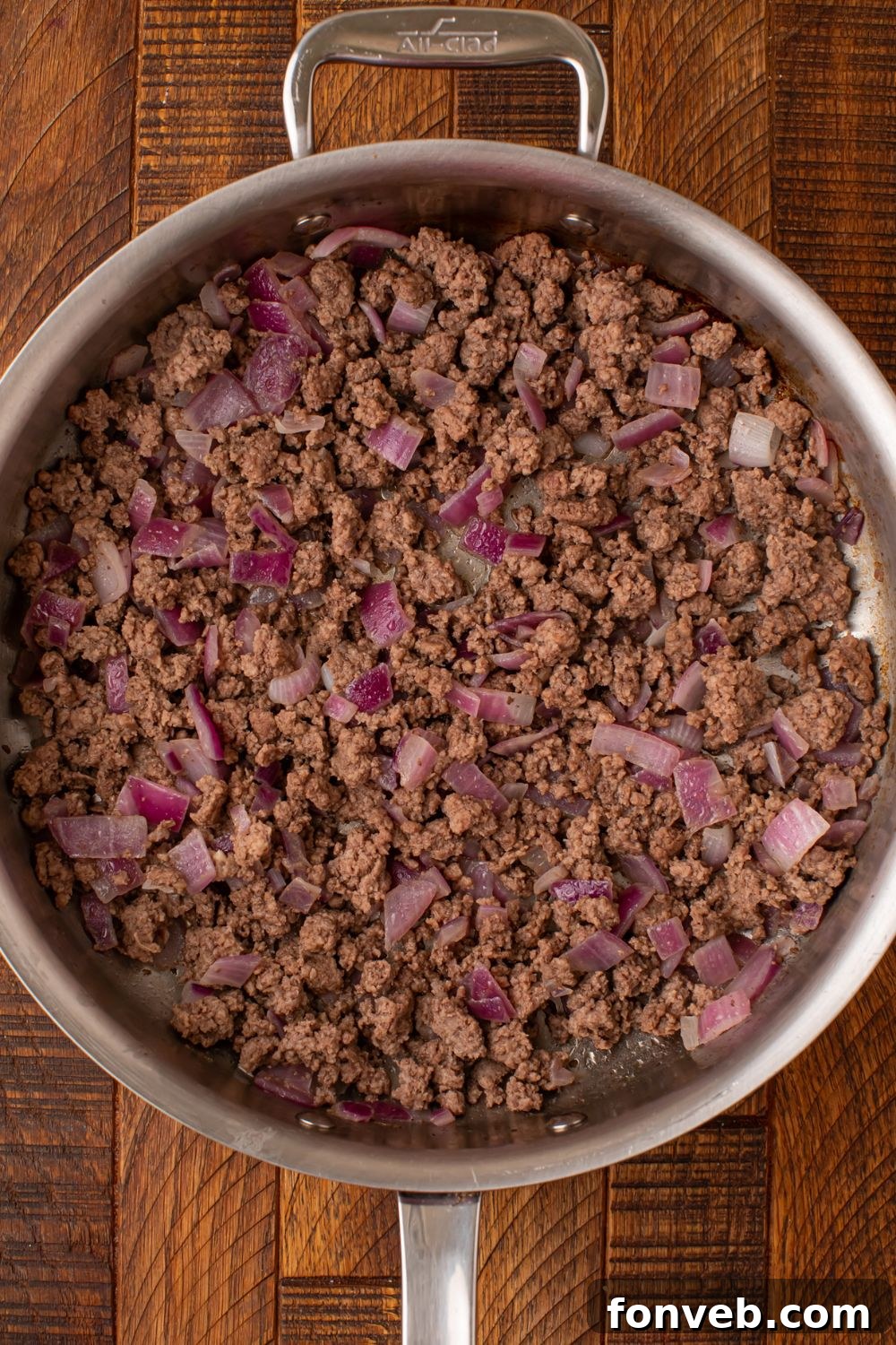 One Pot Cheesy Taco Spaghetti 6 cooked ground beef with peppers in a skillet sitting on the table