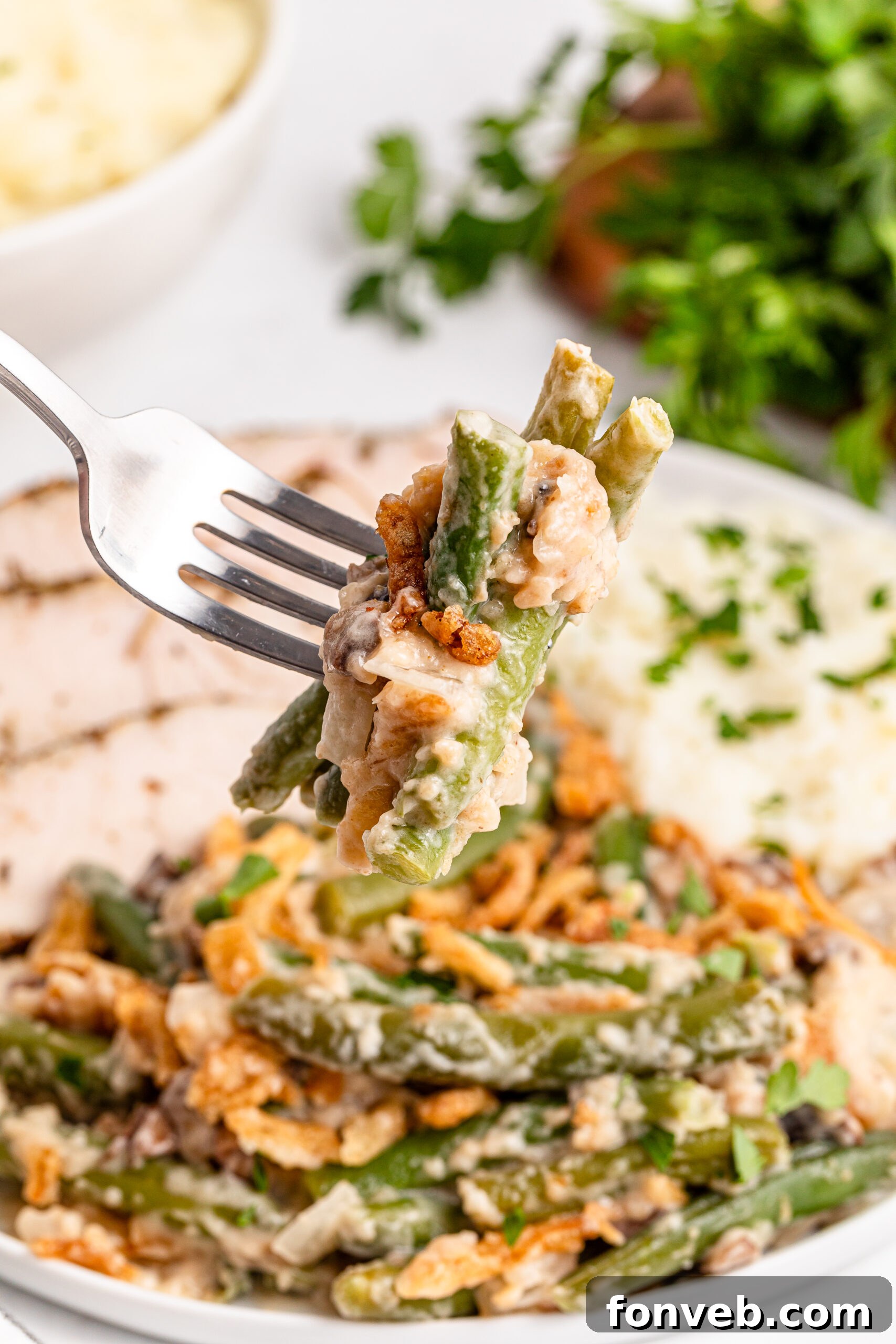a fork holding up a big bite of the Best Ever Green Bean Casserole