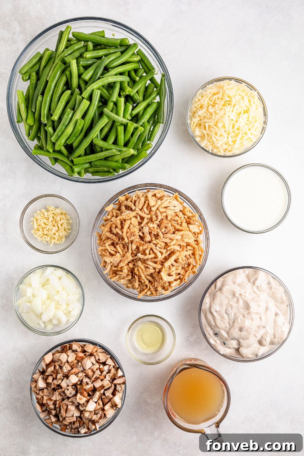 Green Bean Casserole ingredients in single serve bowls on table - green beans, garlic, onion, crispy fried onions, and more