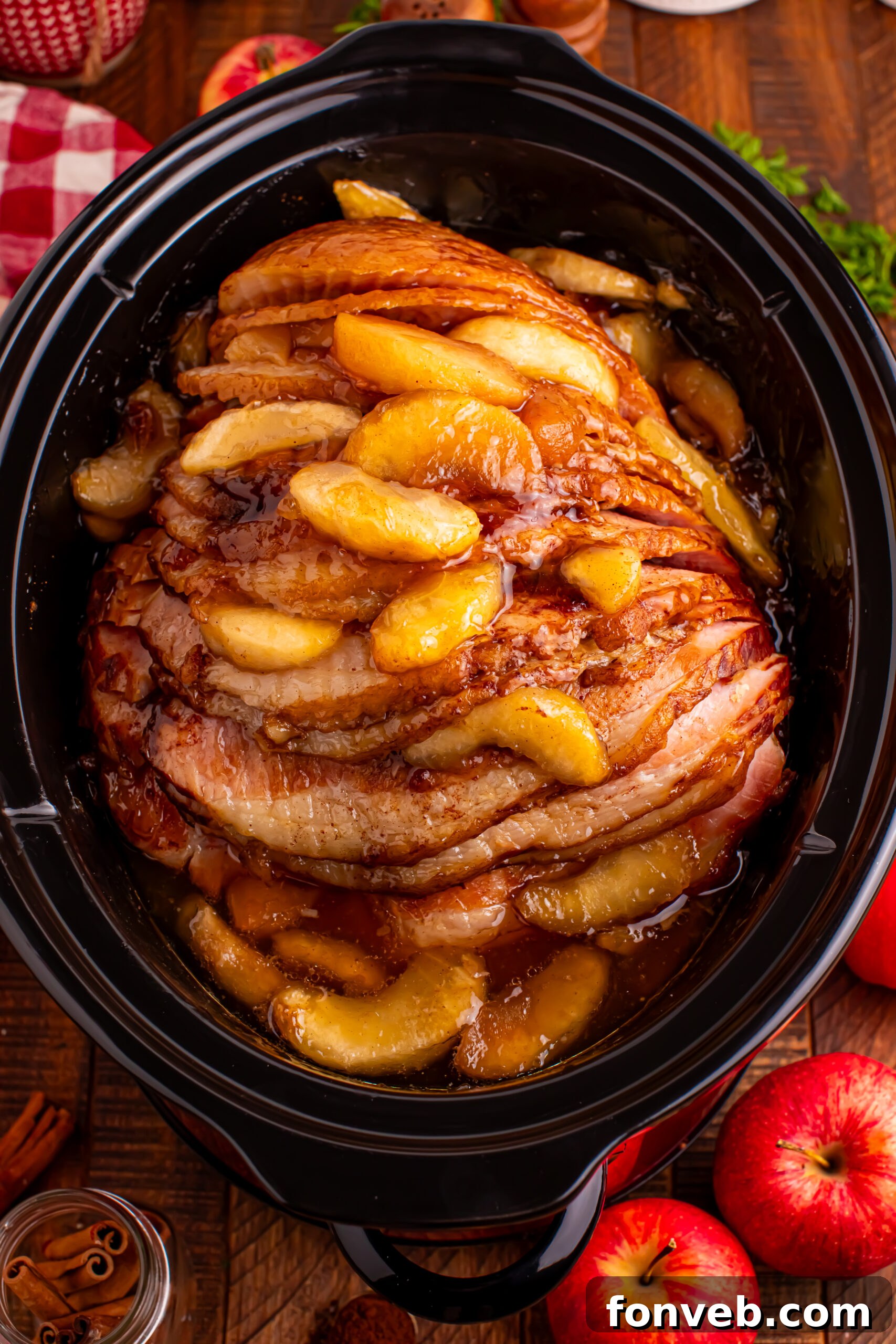 Tender and Juicy Slow Cooker Apple Glazed Ham 19 overhead shot of the cooked Slow Cooker Apple Glazed Ham in a black crock pot on a dark wood table