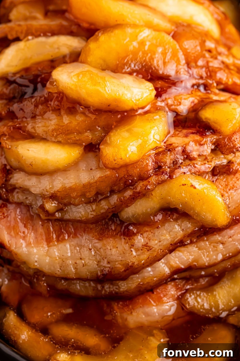Tender and Juicy Slow Cooker Apple Glazed Ham 8 close up look of a cooked spiral cut ham with apple pie filling on top