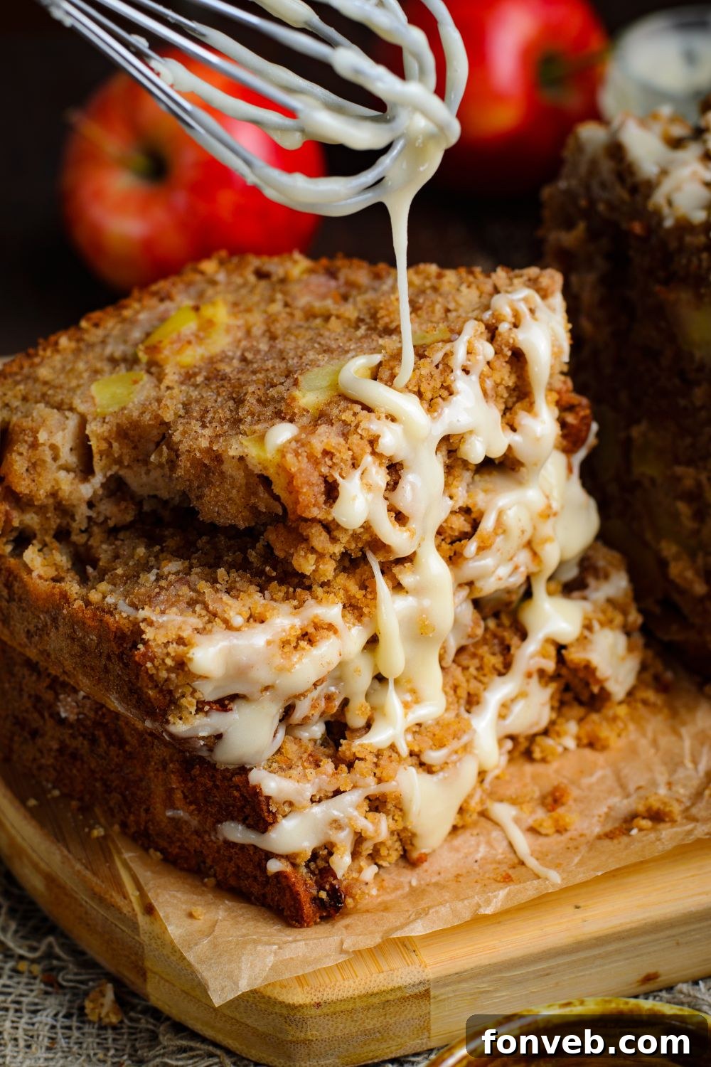 Quick Glazed Apple Cinnamon Loaf 2 Three slices of Apple Cinnamon Loaf Cake, beautifully stacked with a delicate glaze cascading down, on a rustic surface.