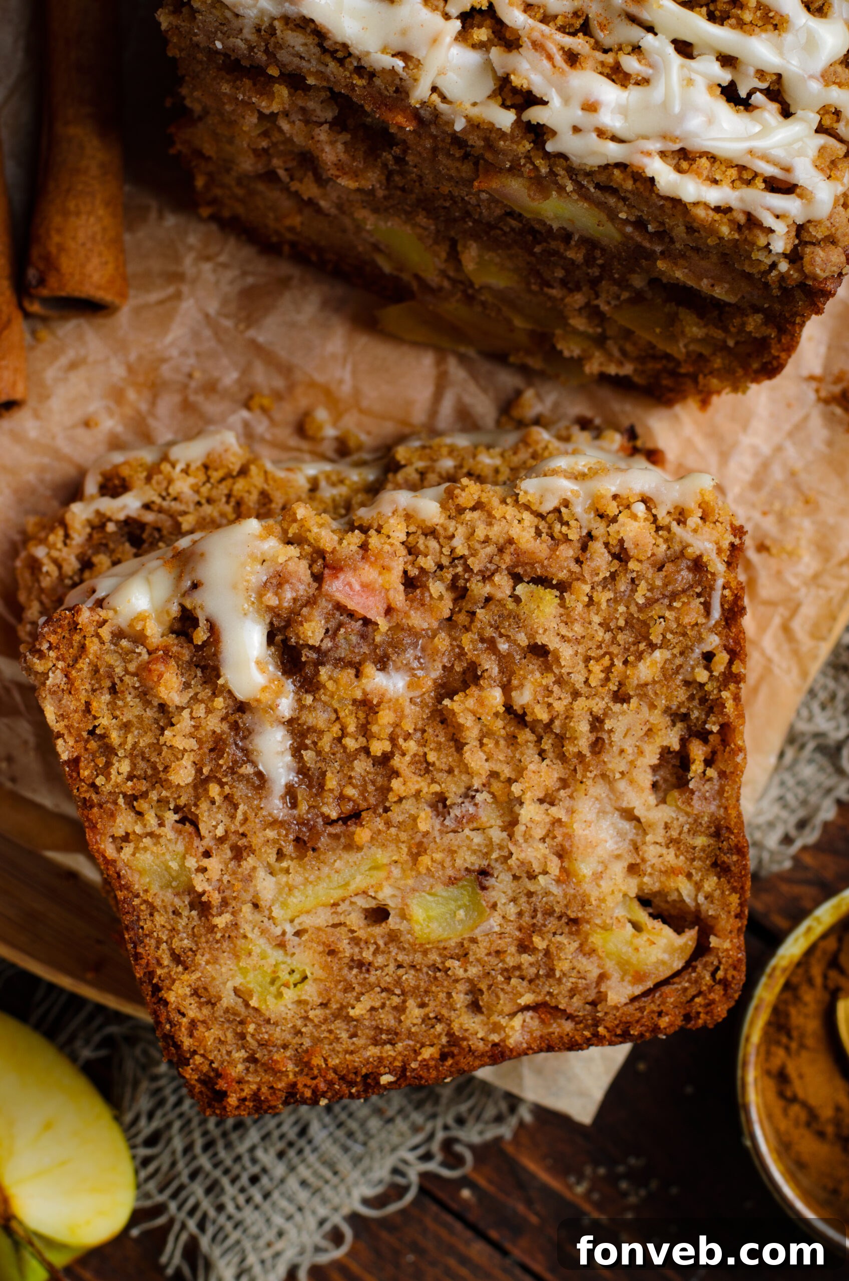 Quick Glazed Apple Cinnamon Loaf 15 A close-up, inviting view of a perfectly sliced piece of Apple Cinnamon Loaf Cake, showcasing its moist, fluffy texture and tender apple chunks within.