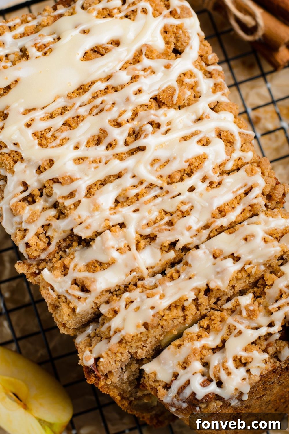 Quick Glazed Apple Cinnamon Loaf 18 A close-up view of an Apple Cinnamon Loaf Cake, beautifully sliced into thick pieces, showcasing its warm, inviting colors and delicious texture on a wooden table.