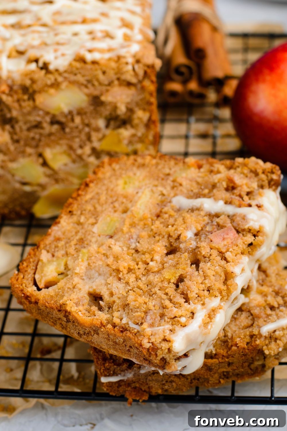 Quick Glazed Apple Cinnamon Loaf 21 Beautifully sliced Apple Cinnamon Loaf Cake pieces are artfully stacked on a table, each generously adorned with a sweet glaze drizzle, ready to be enjoyed.