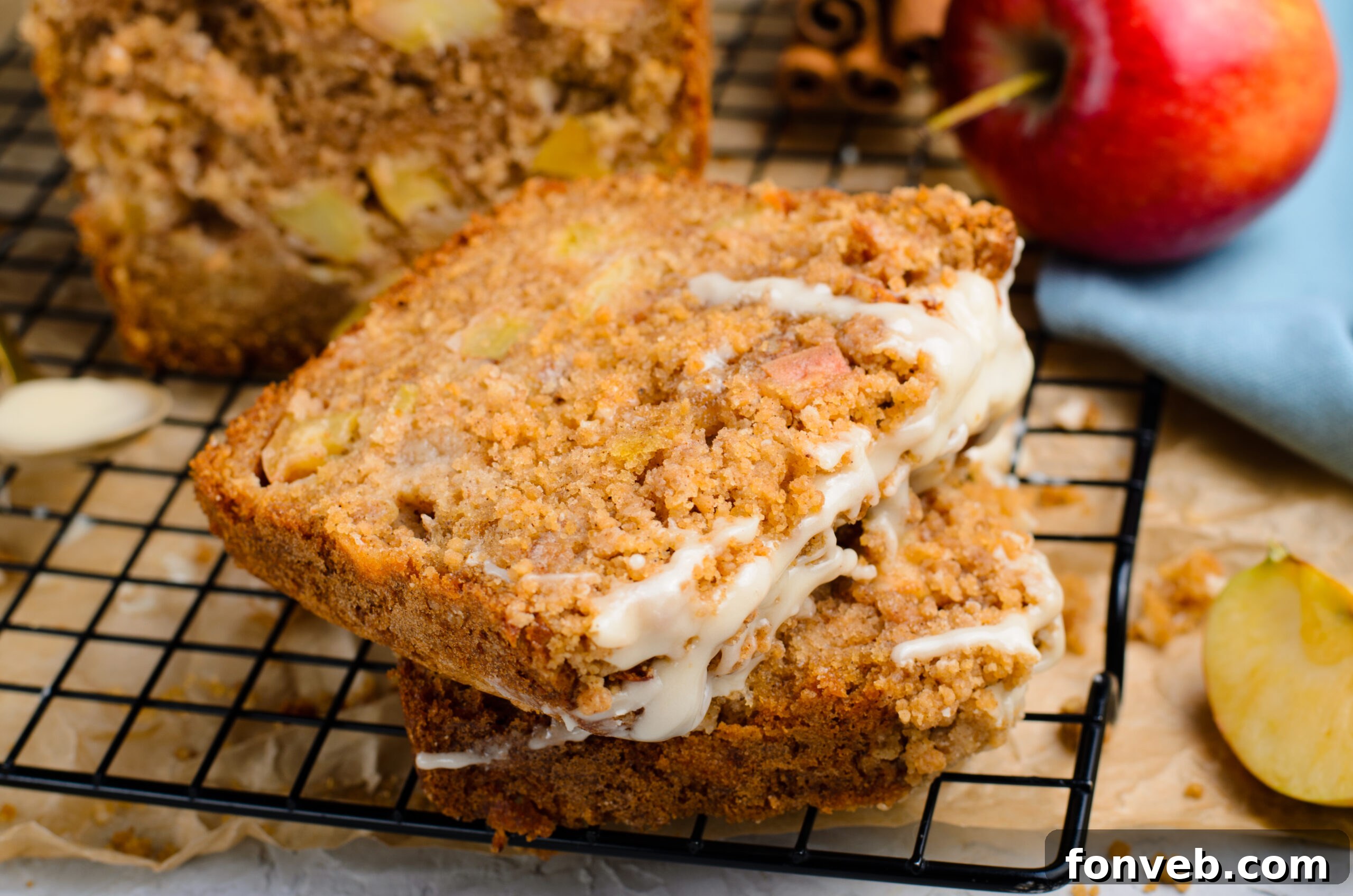 Quick Glazed Apple Cinnamon Loaf 22 A close-up view of two perfectly sliced pieces of Apple Cinnamon Loaf Cake, resting on a cooling rack, showcasing their moist interiors and crumbly tops.