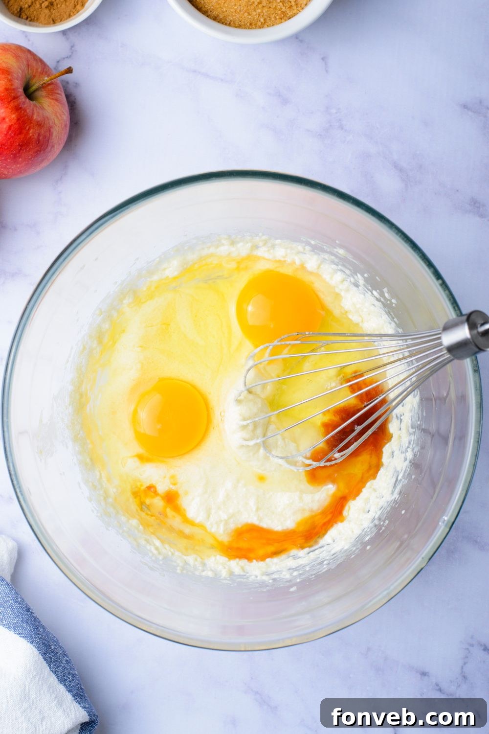 Quick Glazed Apple Cinnamon Loaf 8 A collection of wet ingredients including vanilla and eggs, ready to be incorporated into the dry ingredients for the Apple Cinnamon Loaf Cake, on a kitchen surface.