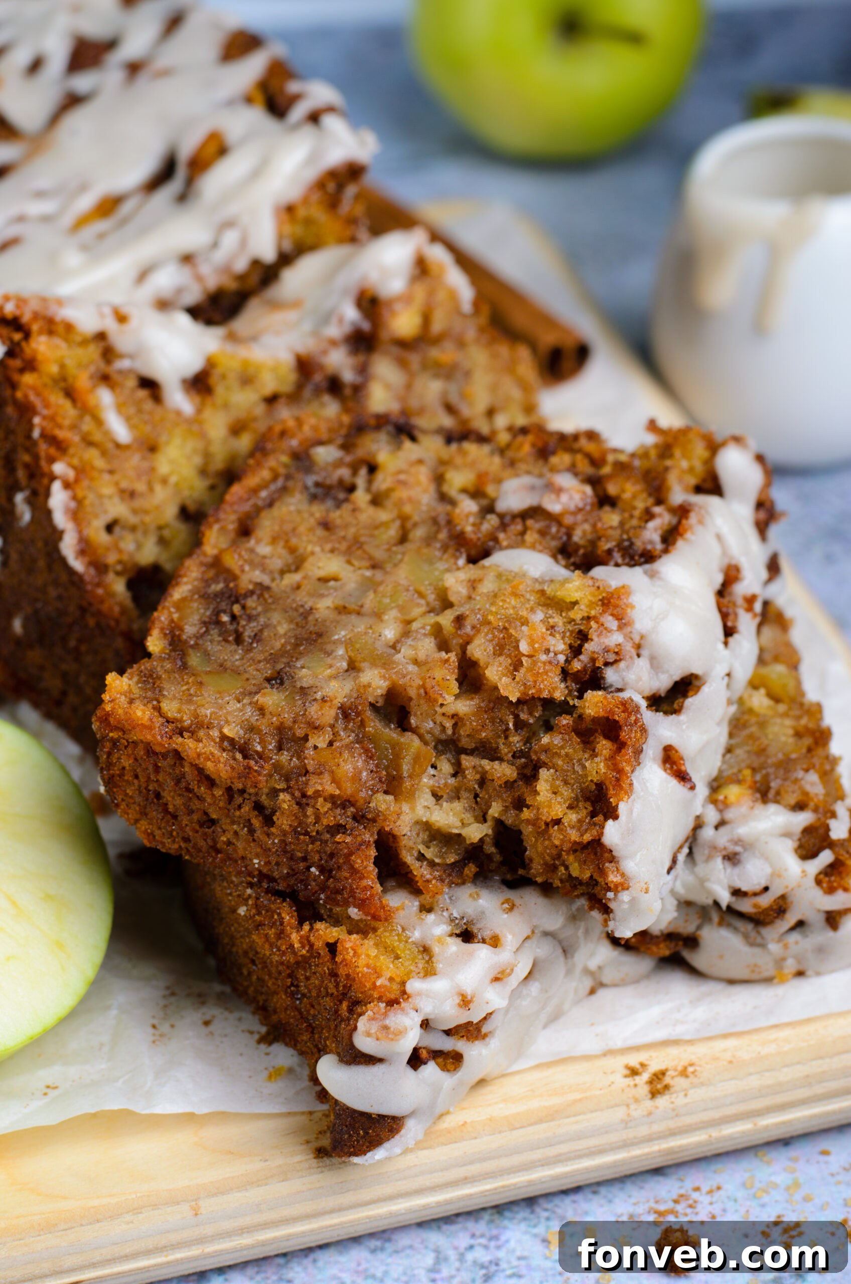two slices of Amish Apple Fritter Bread on a wooden cutting board 