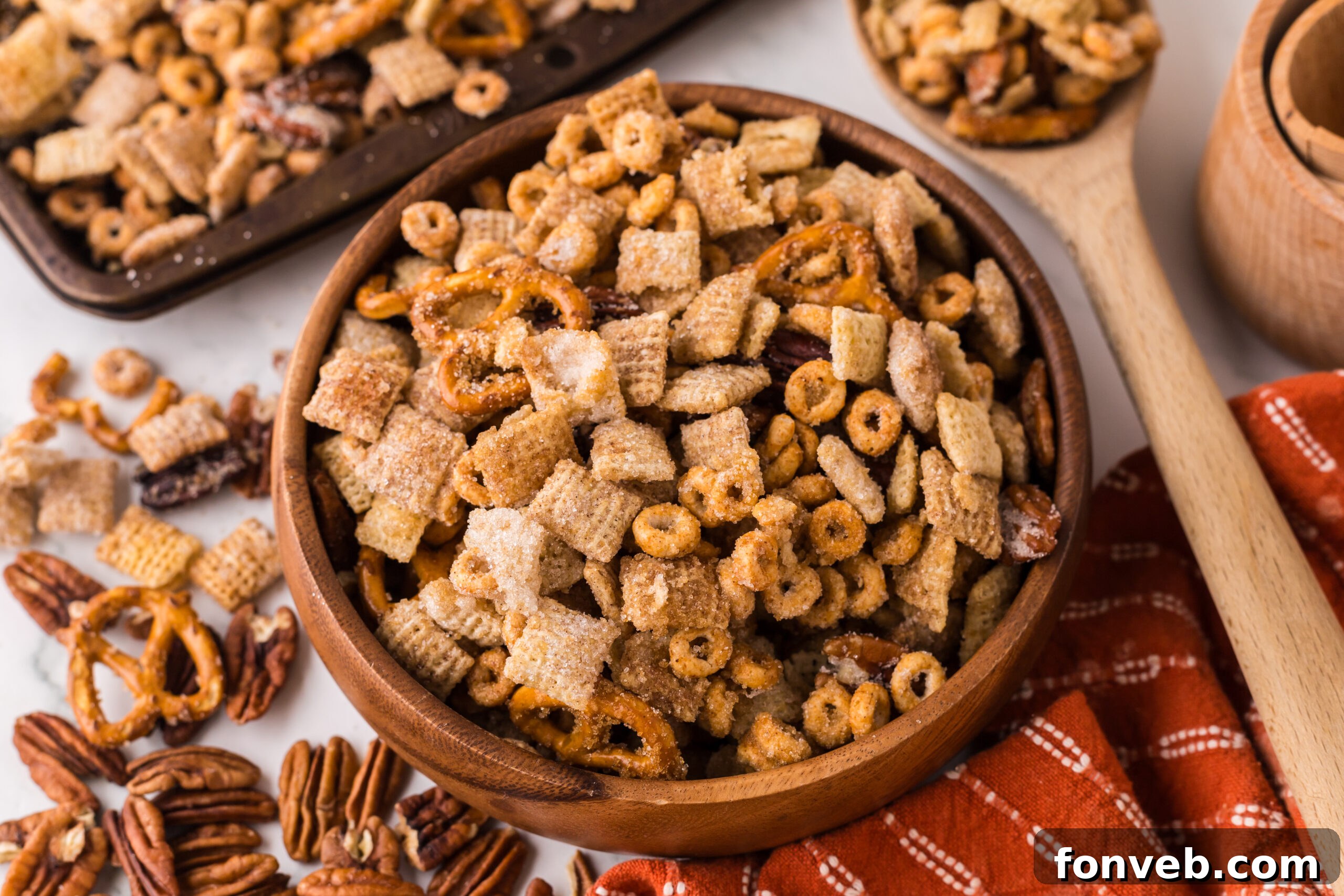 Pumpkin Spice Chex Mix in a wooden serving bowl on a white marble table