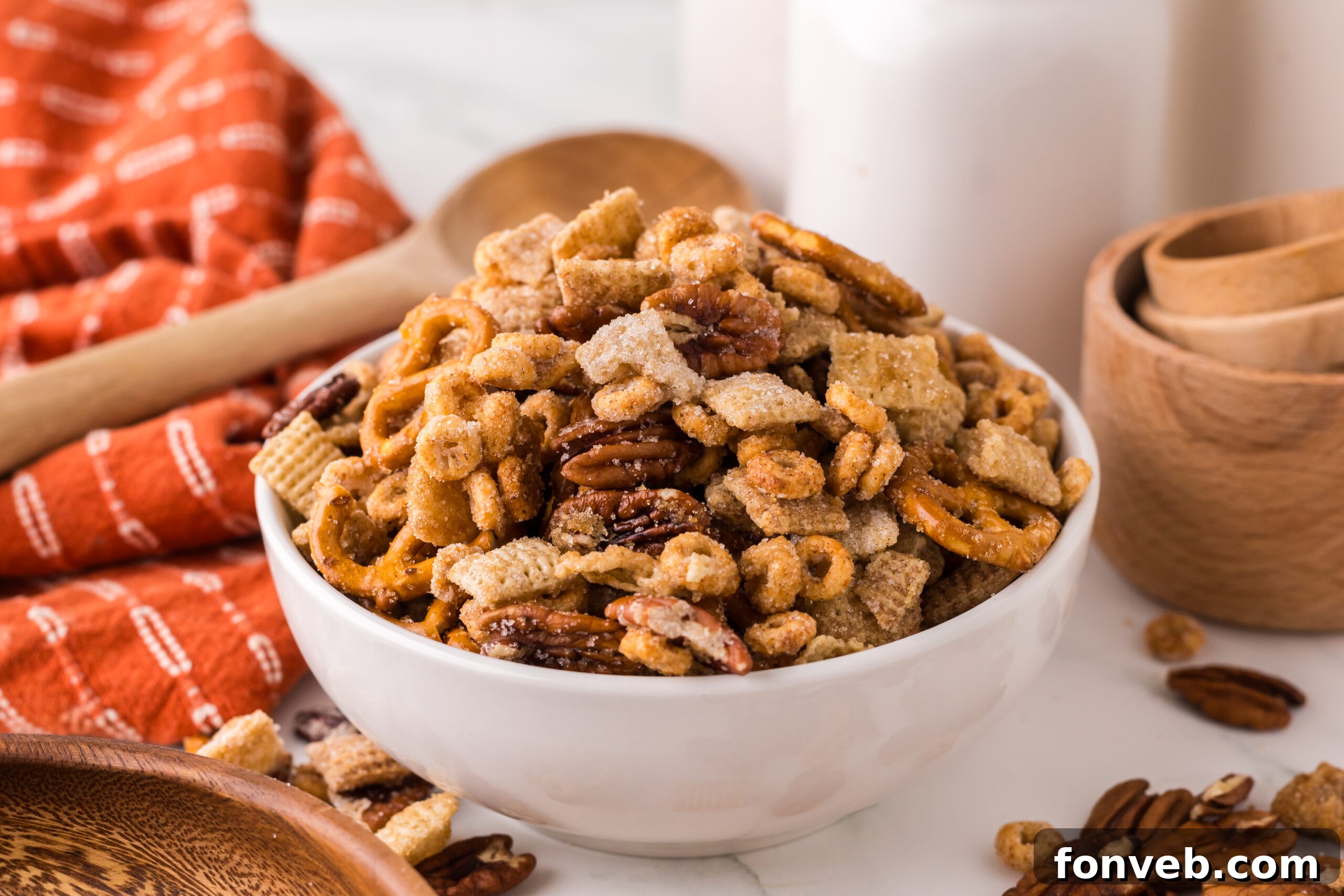 Pumpkin Spice Chex Mix in a white serving bowl on a white marble table 