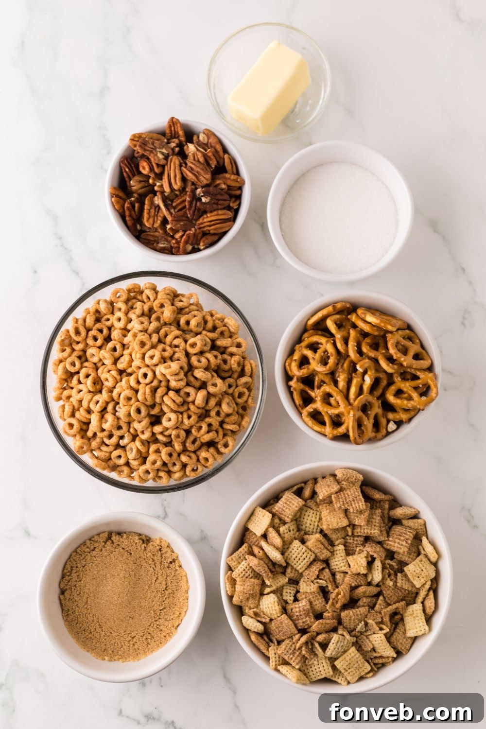Pumpkin Spice Chex Mix ingredients all in single serve bowls sitting on a marble counter 